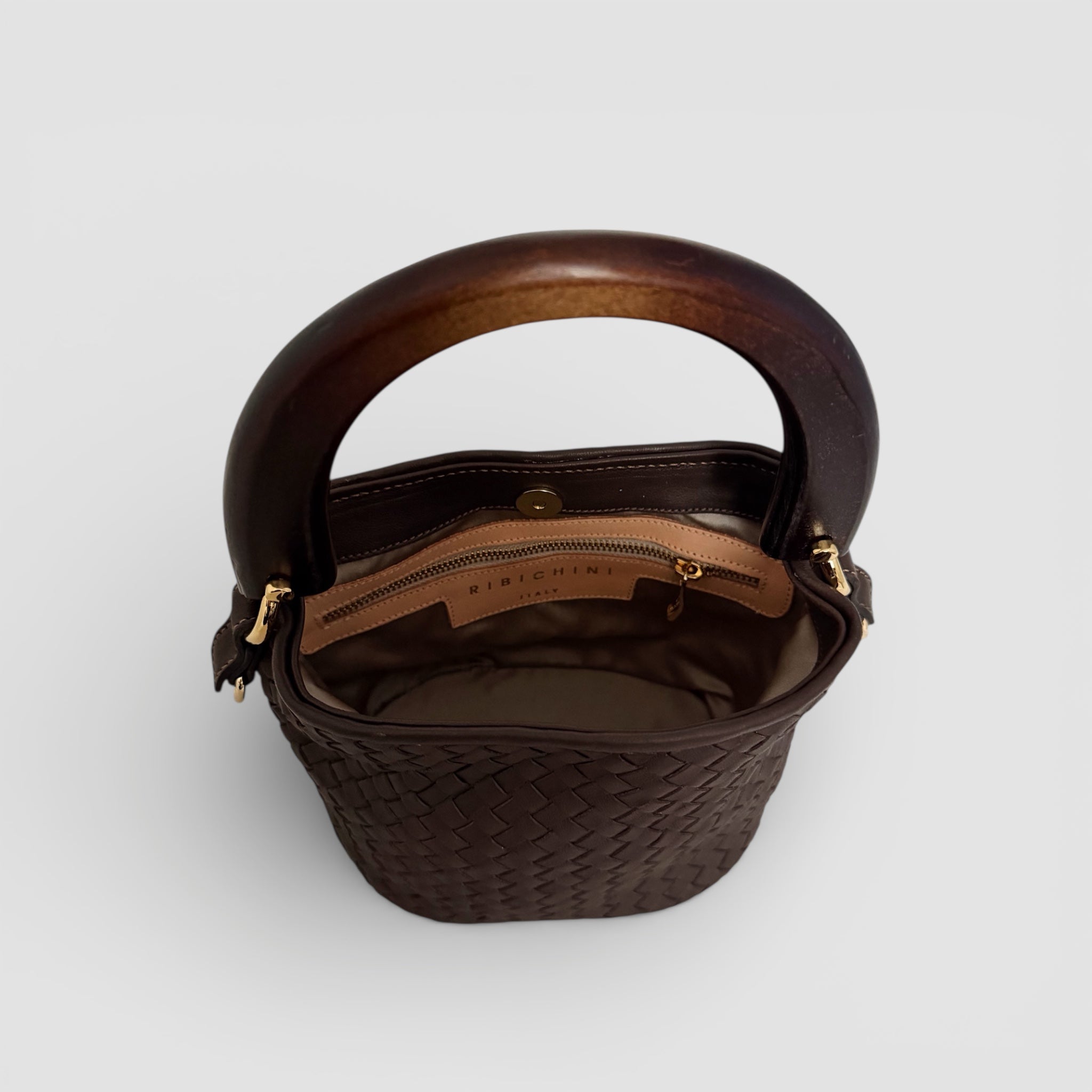Innside av Ribichini Albero veske med skinnfôr, magnetlukking og innvendig glidelåslomme, håndlaget i Italia.