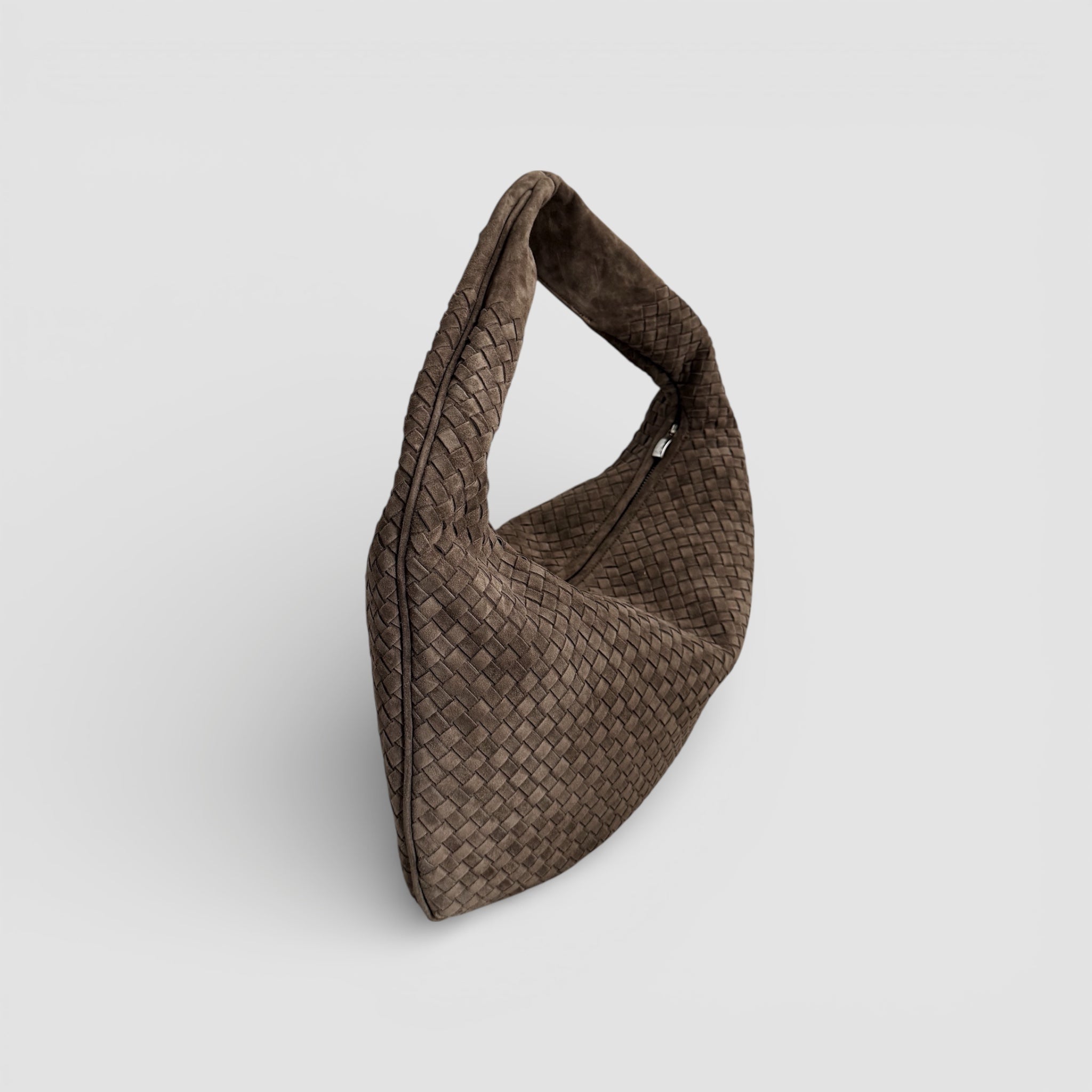 Ribichini Isola Royal Smoke i semsket skinn, håndflettet veske vist fra siden med myk form og skulderhank.