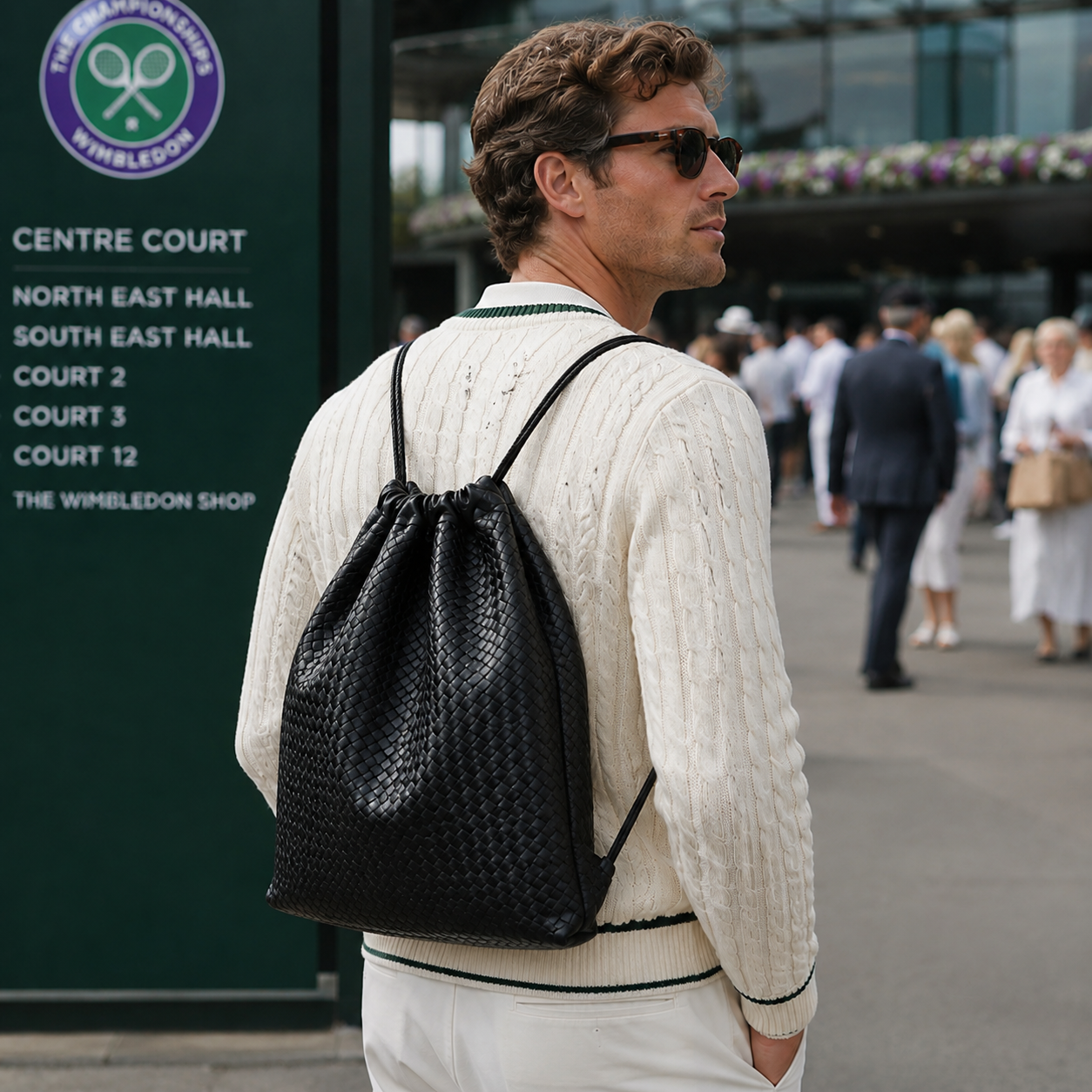 "Mann med Ribichini Sacco i svart håndflettet skinnsekk på Wimbledon, italiensk design i eksklusivt lammeskinn."