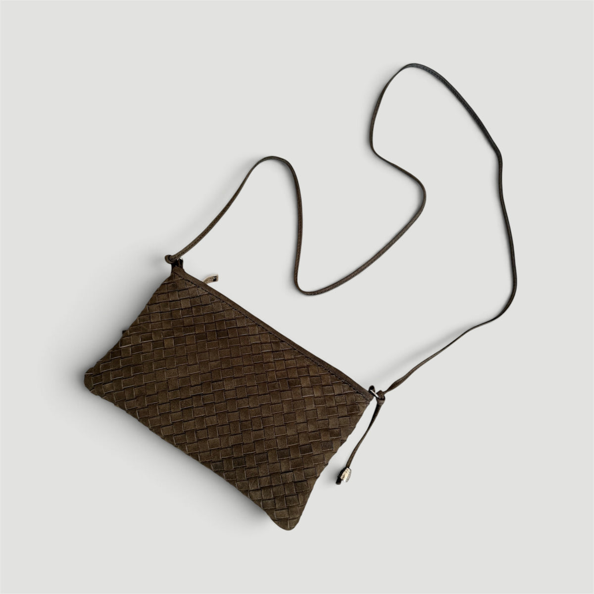 Ribichini Camper Clutch Suede Olive – håndflettet clutch i olivengrønt semsket skinn, sett ovenfra med lang skulderrem.