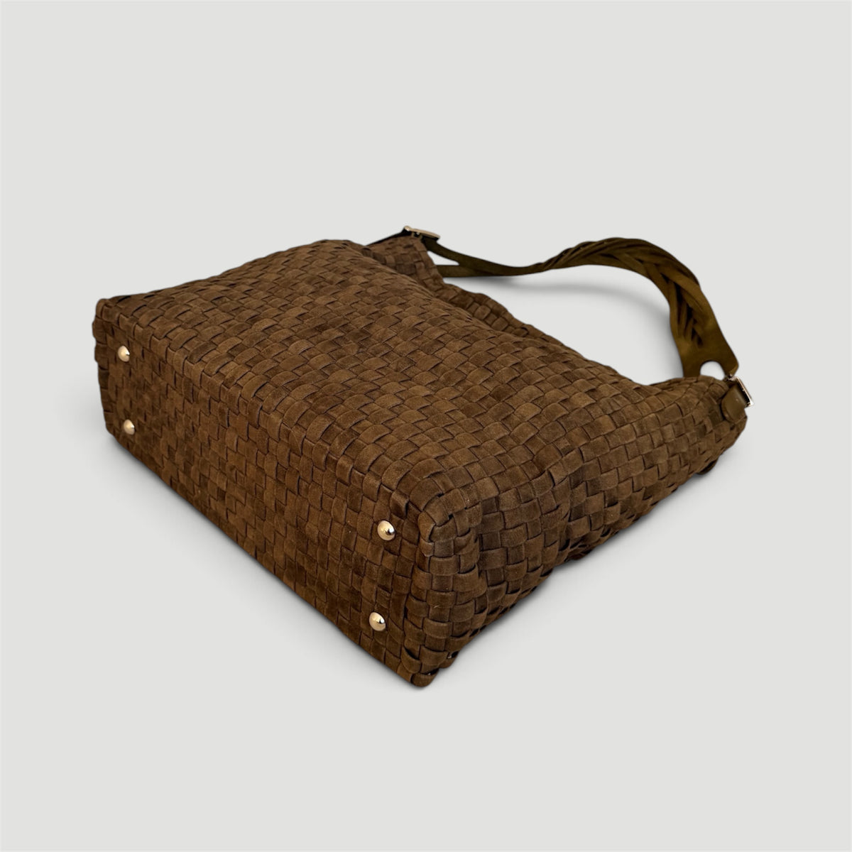 Ribichini Camper Suede Olive – detaljbilde av håndflettet semsket lammeskinn og gullfargede beskyttelsesknotter under vesken.
