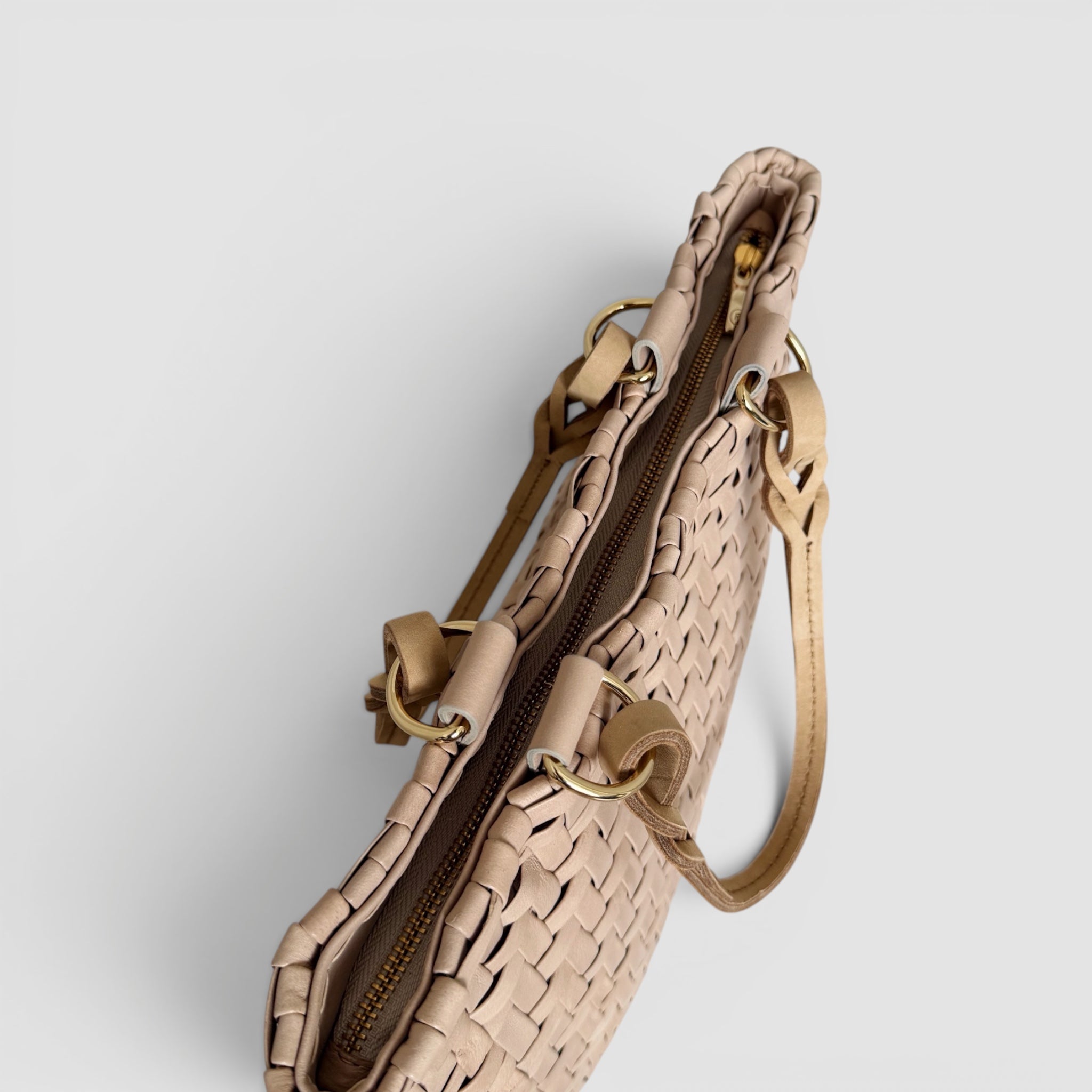 Bildet viser Ribichini Safari Lady-vesken i lattefarge, med flettet lammeskinn og gullglidelås. Elegant og praktisk med unikt mønster.