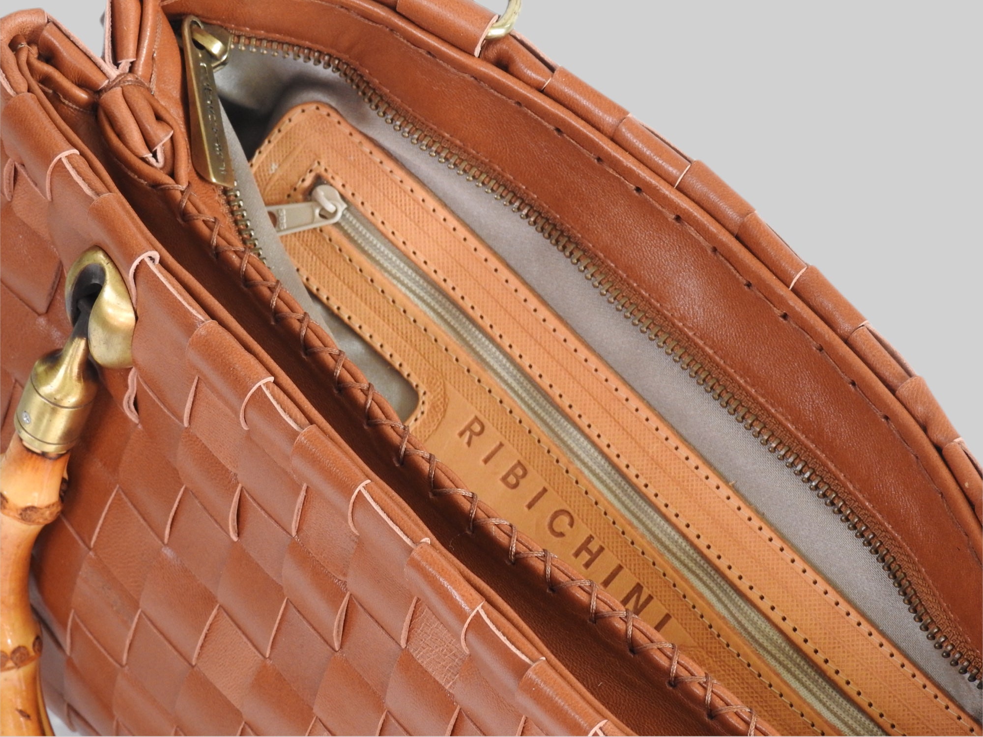 Innsiden av en Ribichini Bamboo skinnveske, der man kan se de forskjellige glidelåsene som brukes til å organisere og oppbevare ting.