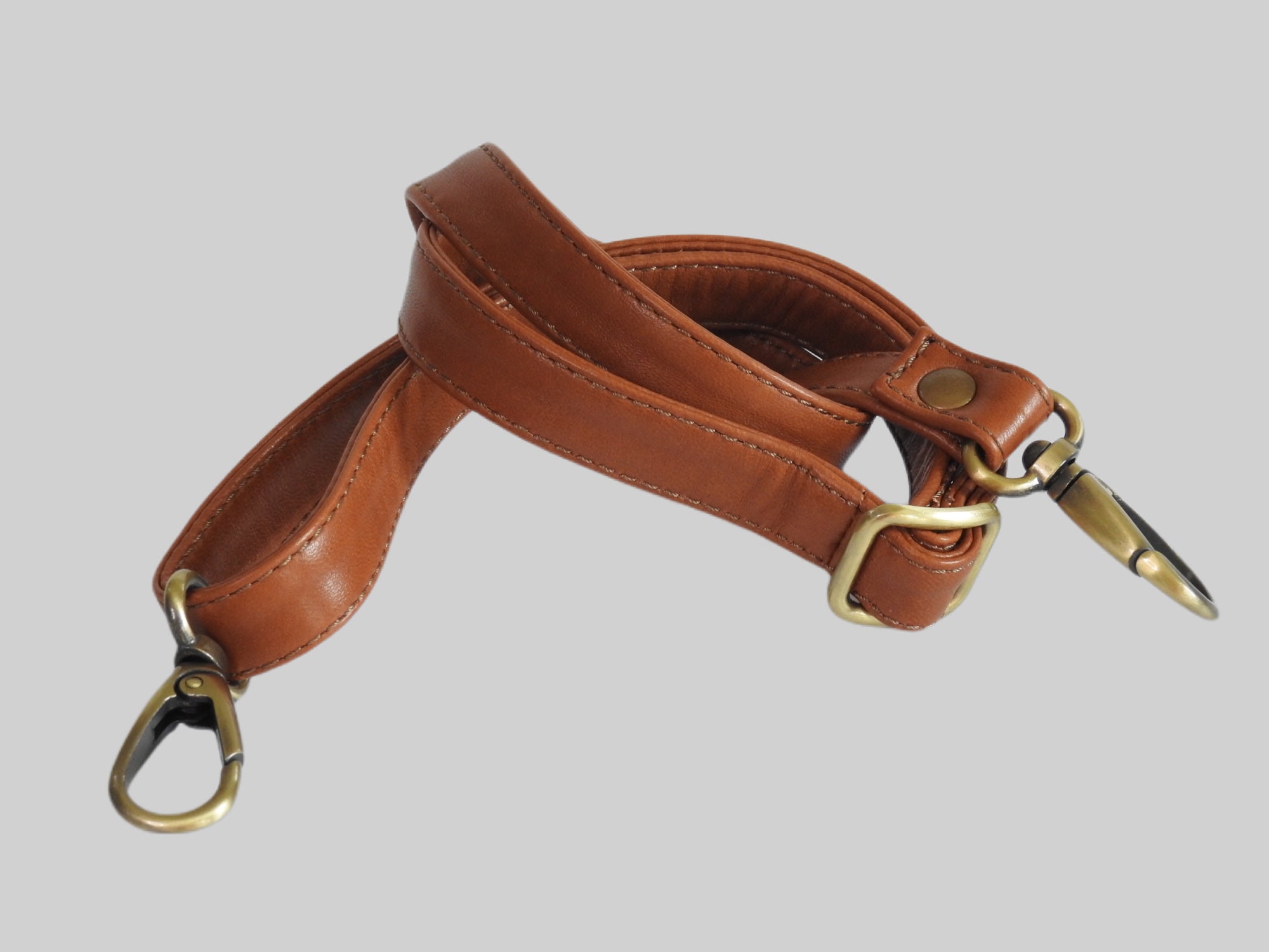 Skulderstropp i fargen cognac med gulldetaljer som følger med Ribichini Bamboo skinnvesken.