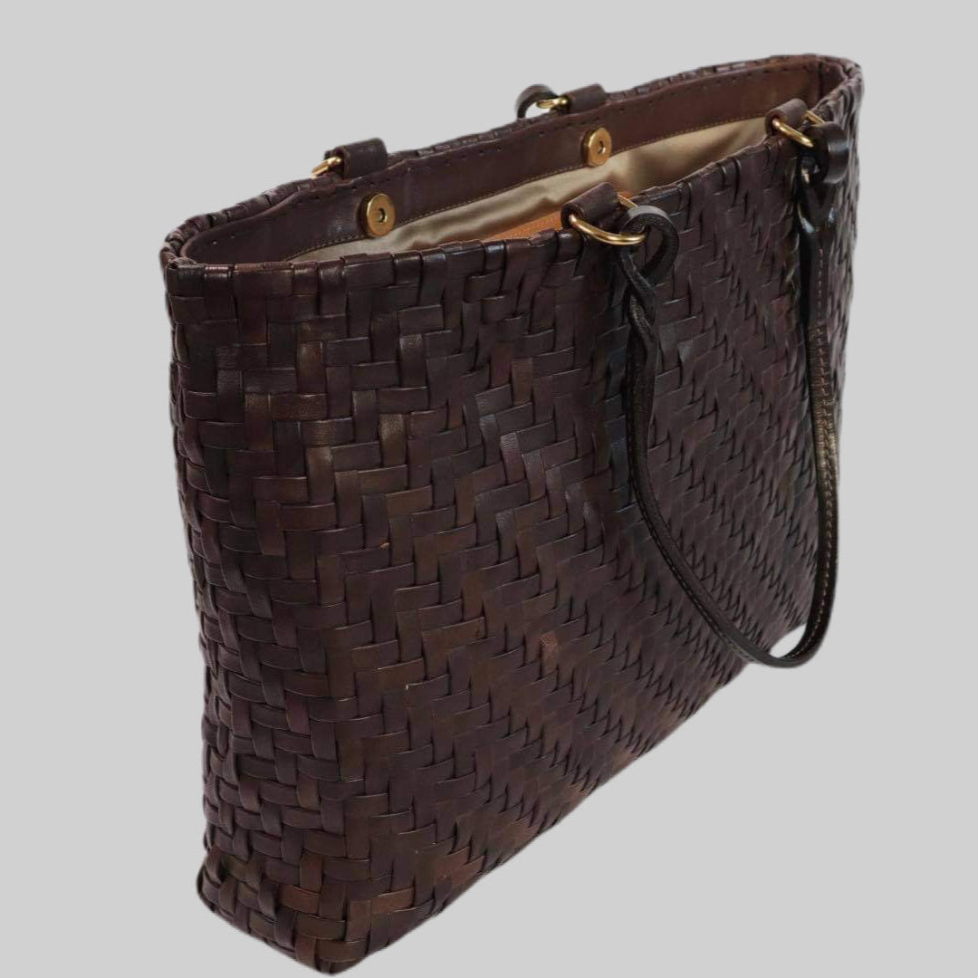 Bildet viser siden av Ribichini Safari-vesken, med flettet fiskebensmønster i brunt lammeskinn og vakre detaljer på hankene for ekstra eleganse.