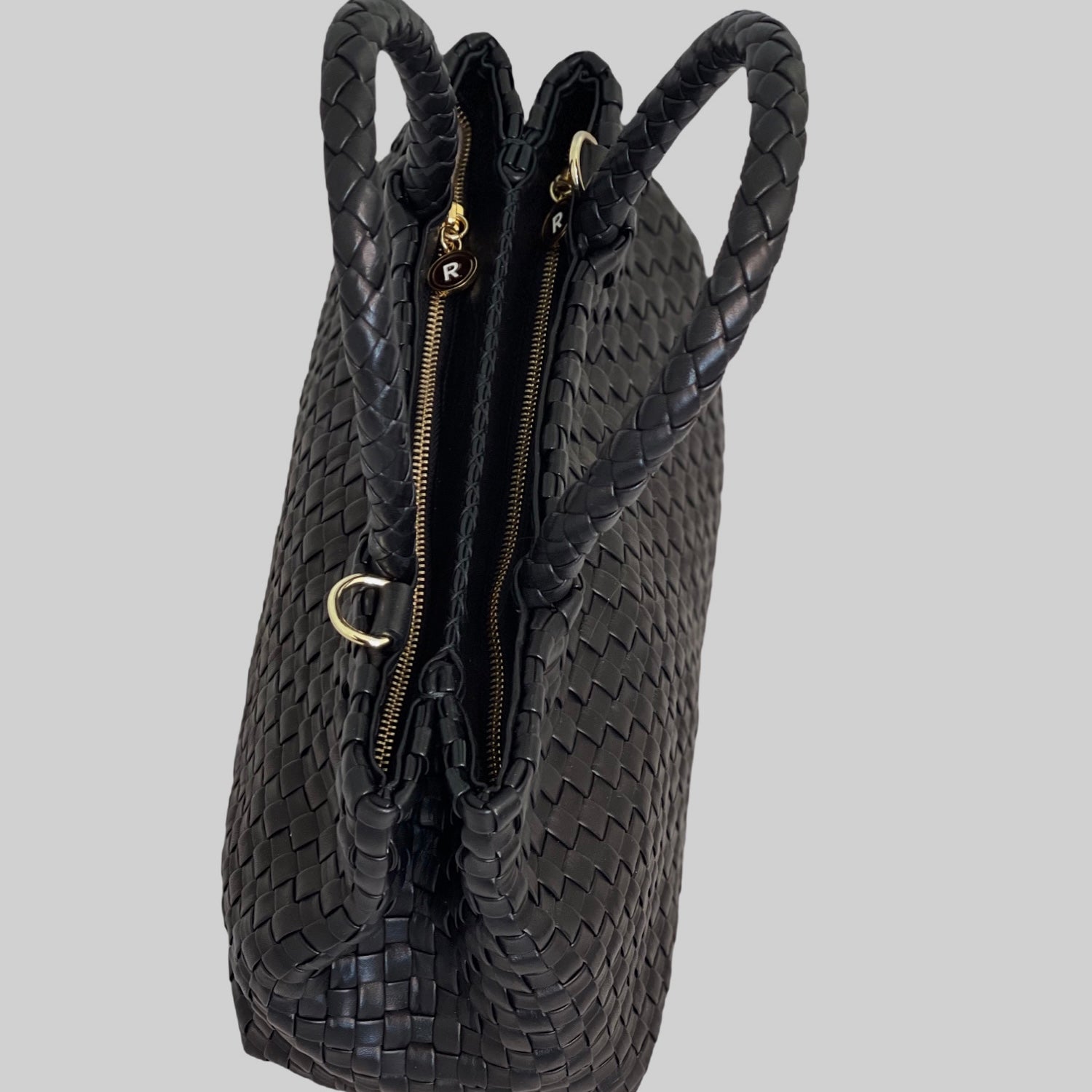 Når sett fra oversiden, viser Ribichini Ginny-vesken sin romslighet og organisering med to rom som har glidelåser. De elegante gulldetaljene gir et luksuriøst preg og et raffinert utseende.