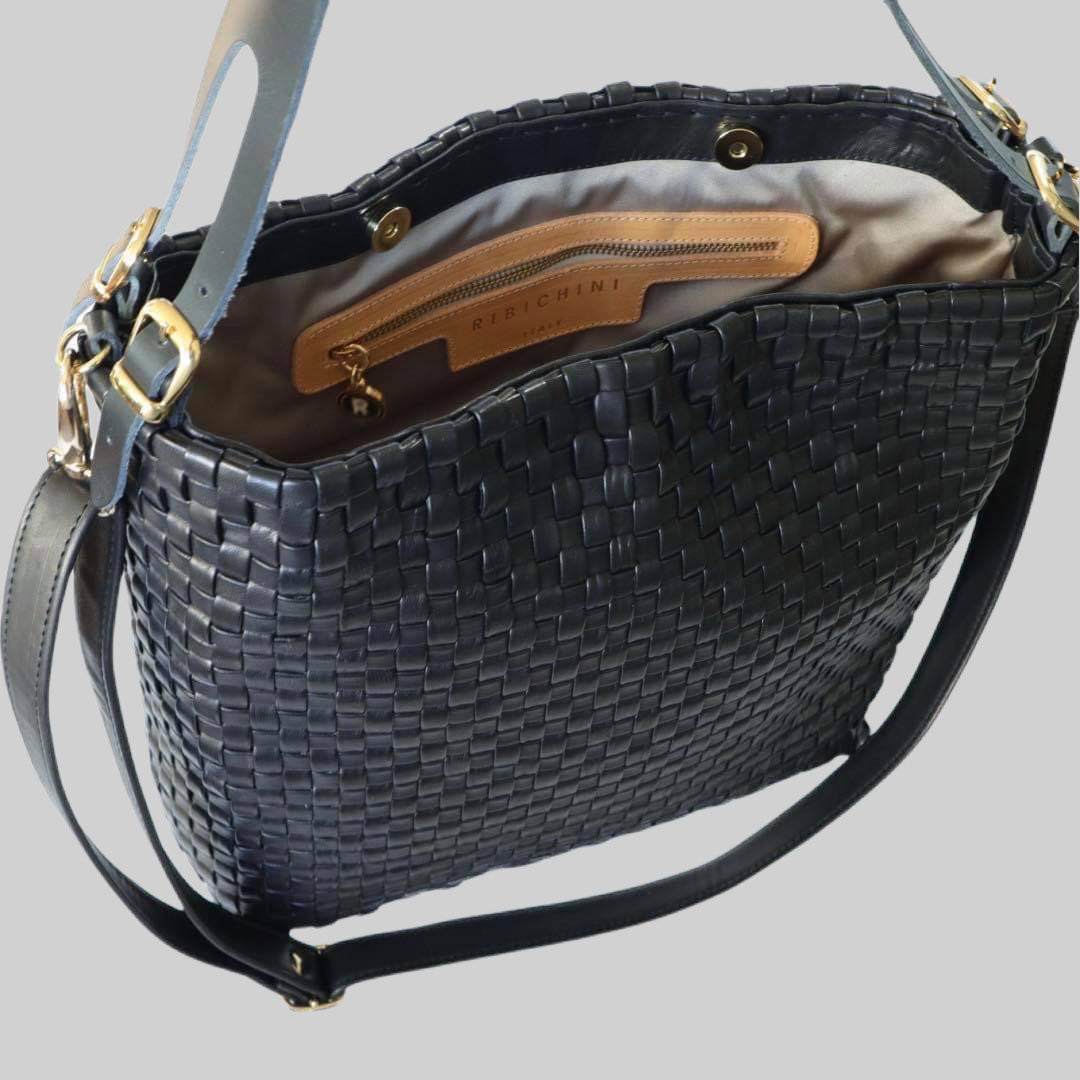 Gulldetaljer glitrer mot sort skinn, fremhever luksus og eleganse på Ribichini Camper skinnvesken.