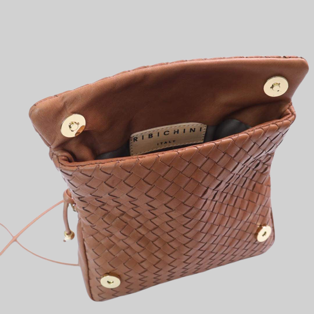 Ribichini Undercover skinnveske i Cognac: Allsidig flettet skinnveske. Kan brettes og lukkes enkelt. Magnetsikring. Elegante gulldetaljer.