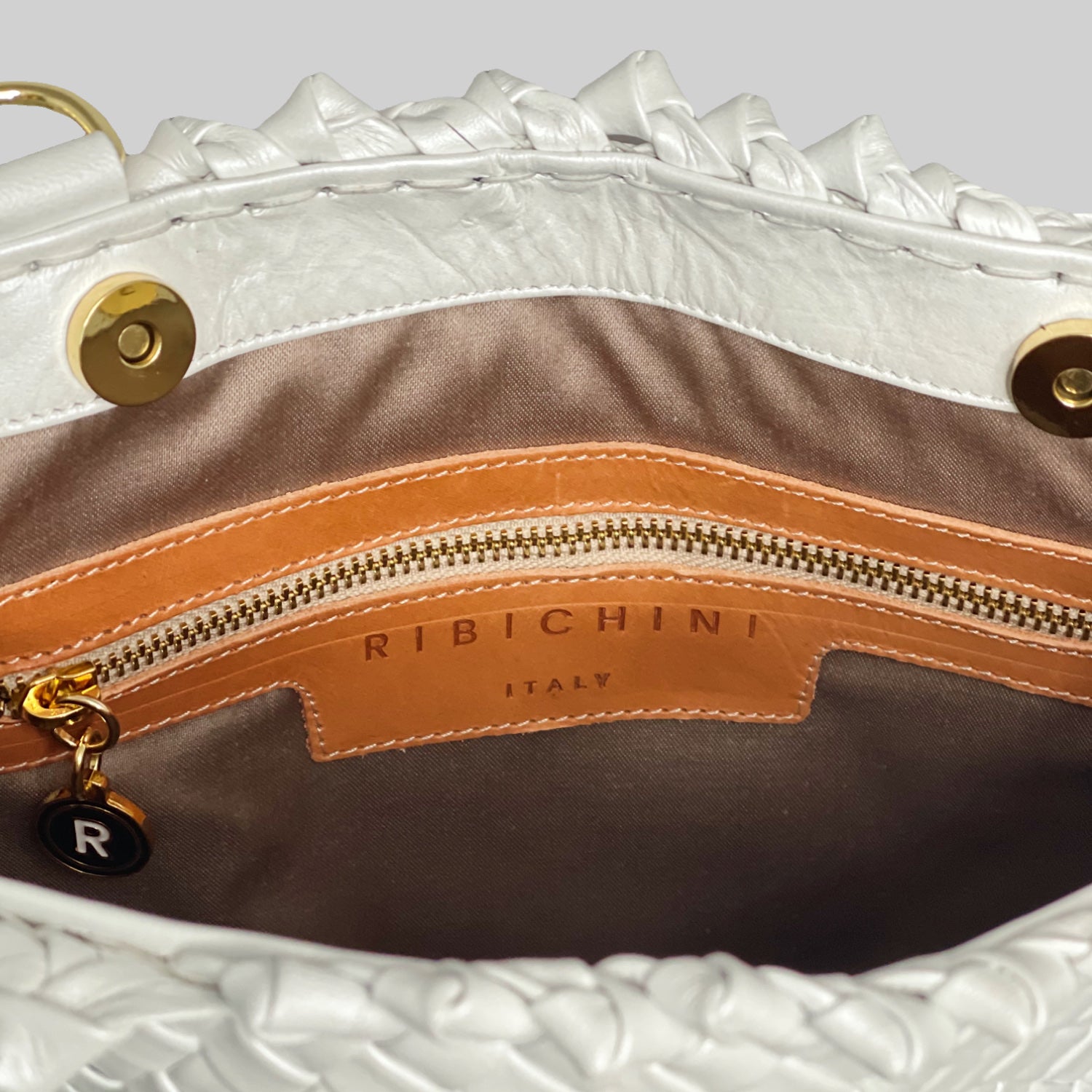 Ribichini Woodstock Babe skinnveske i hvitt har en elegant gullfarget glidelås og R-logo, med flere lommer innvendig for praktisk organisering.
