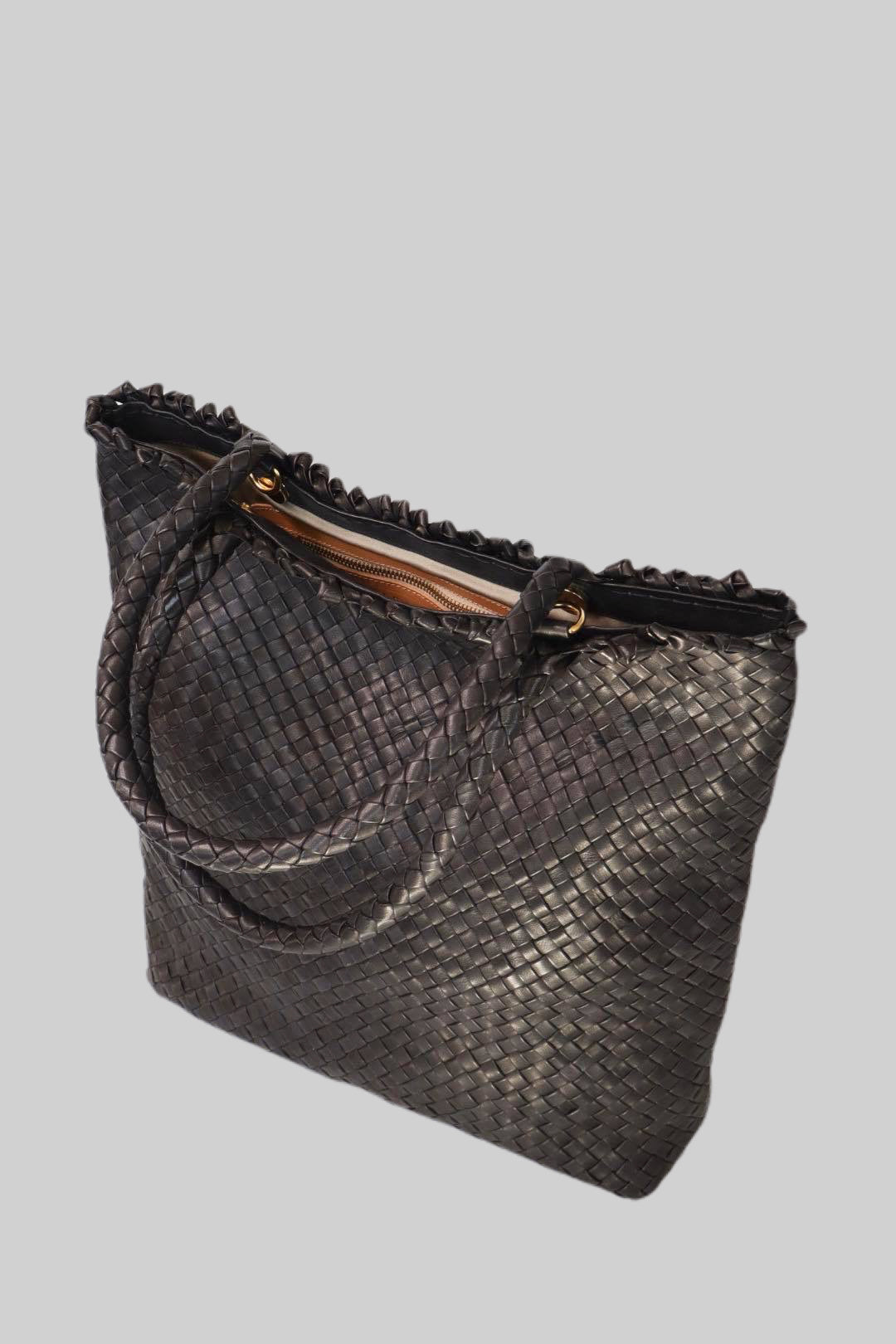 Sidevisning av Ribichini Woodstock veske i sort flettet skinn. Detaljert flettemønster og rikt lammeskinn gir sofistikert eleganse.