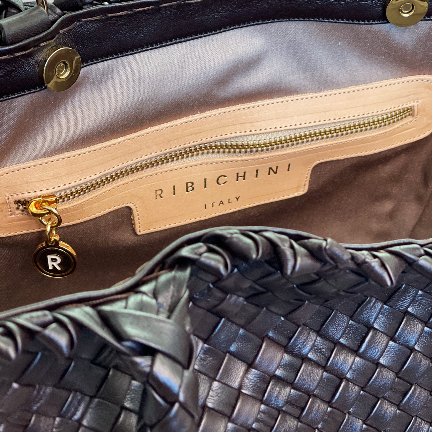 Innsiden av Ribichini Woodstock Classic skinnveske i chocolate viser en gullfarget glidelåslomme og den ikoniske R-logoen.