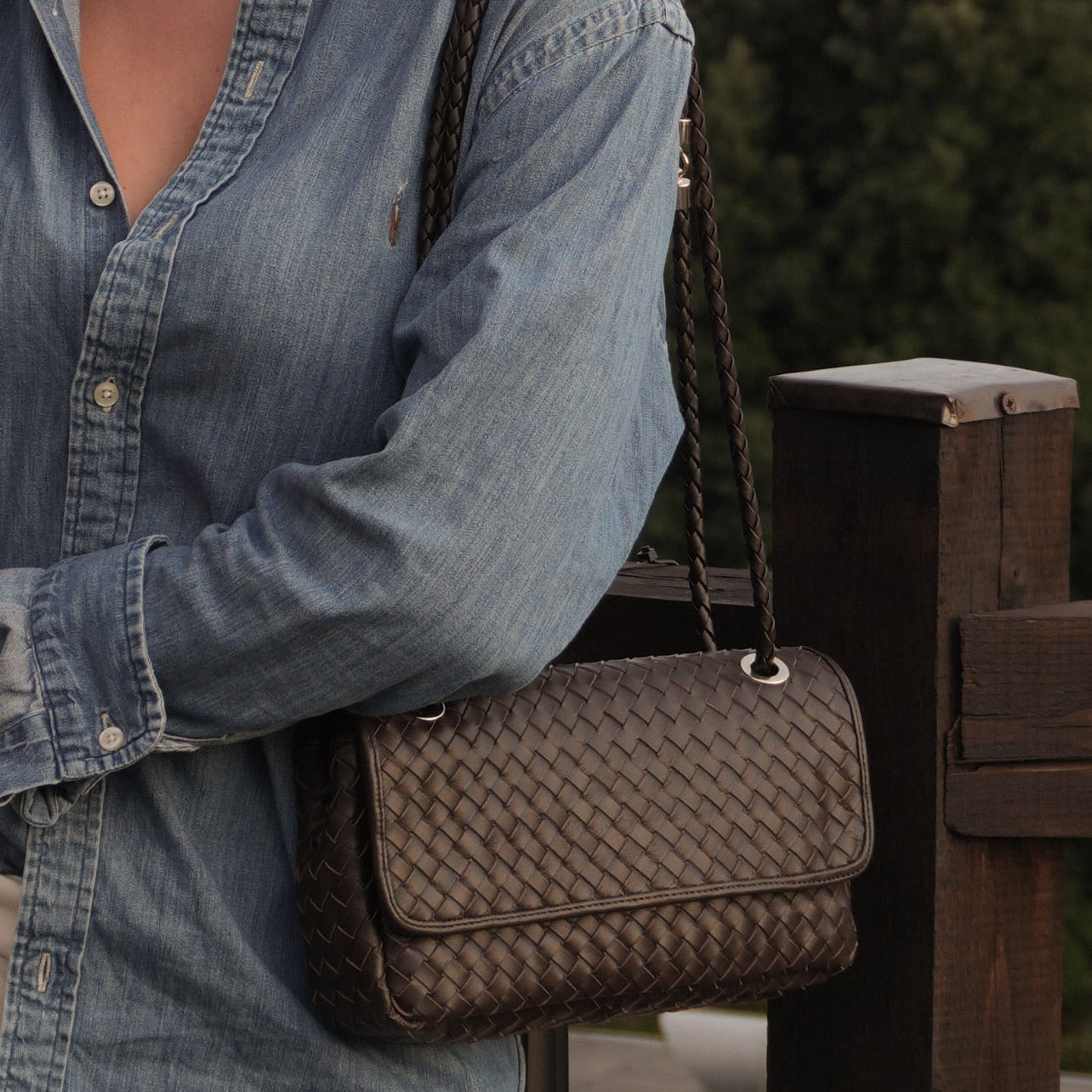 Ribichini Envelope-veske i flettet sjokoladebrunt skinn, stylet med blå dongeriskjorte. 