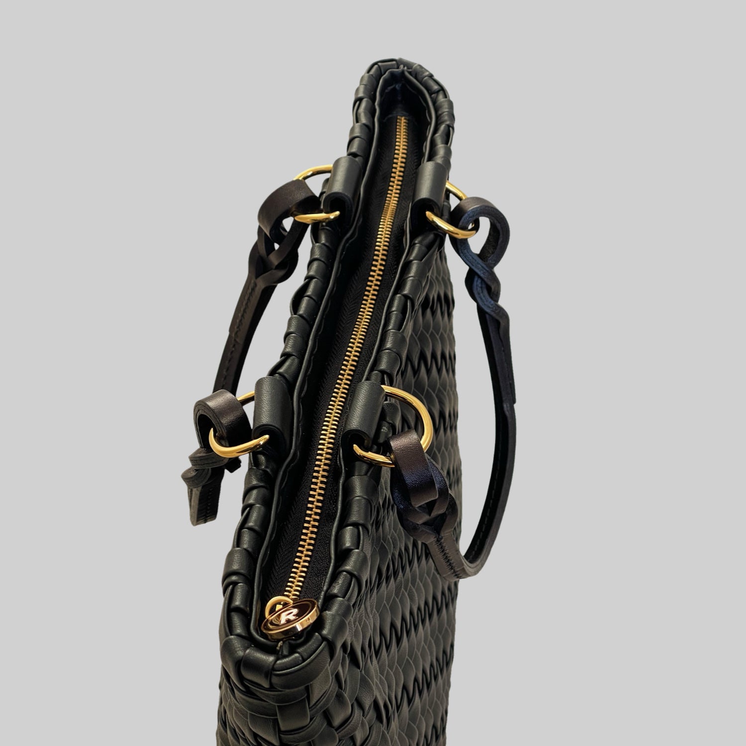  Ribichini Safari Lady-vesken i sort, med flettet lammeskinn og glidelås, kombinerer stil og funksjonalitet på en elegant måte.