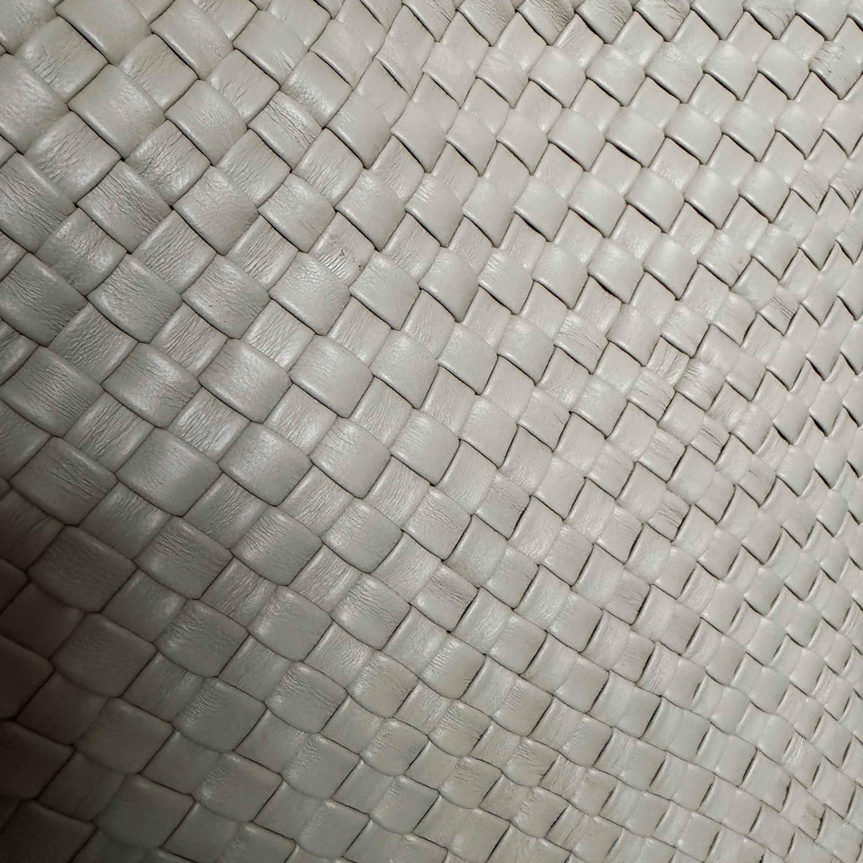 Detaljbilde av håndflettet skinn i fargen ice med tett flettestruktur.