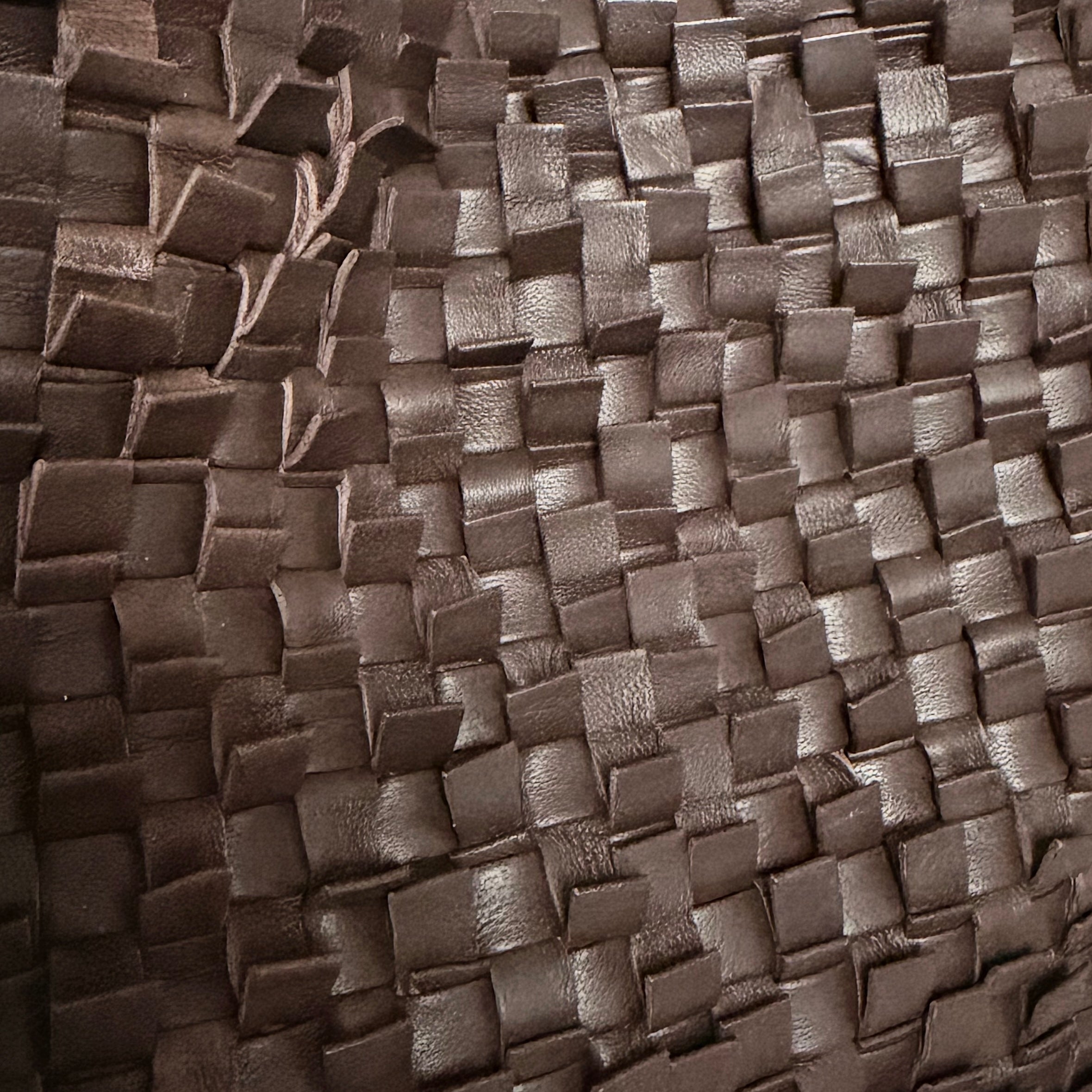 Detaljbilde av Loren i brunt med håndflettet plissé-skinn.