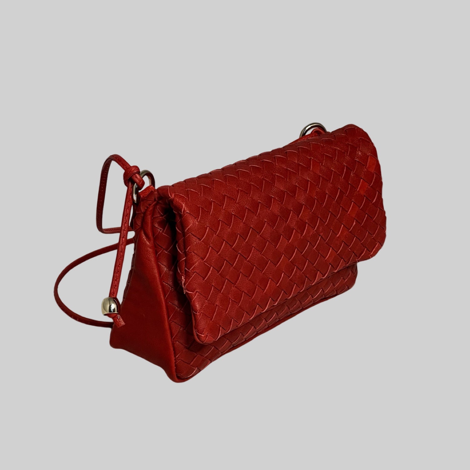Ribichini Undercover veske i rødt: kompakt, sikker lukking med magneter, elegant design. Sidevisning viser brettemekanismen.