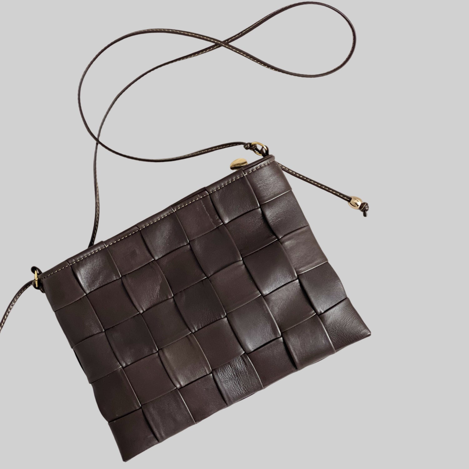 Ribichini Square Clutch i fargen chocolate: Elegant og kompakt design med store, flettede ruter. Håndlaget kvalitet og høykvalitetsmaterialer.