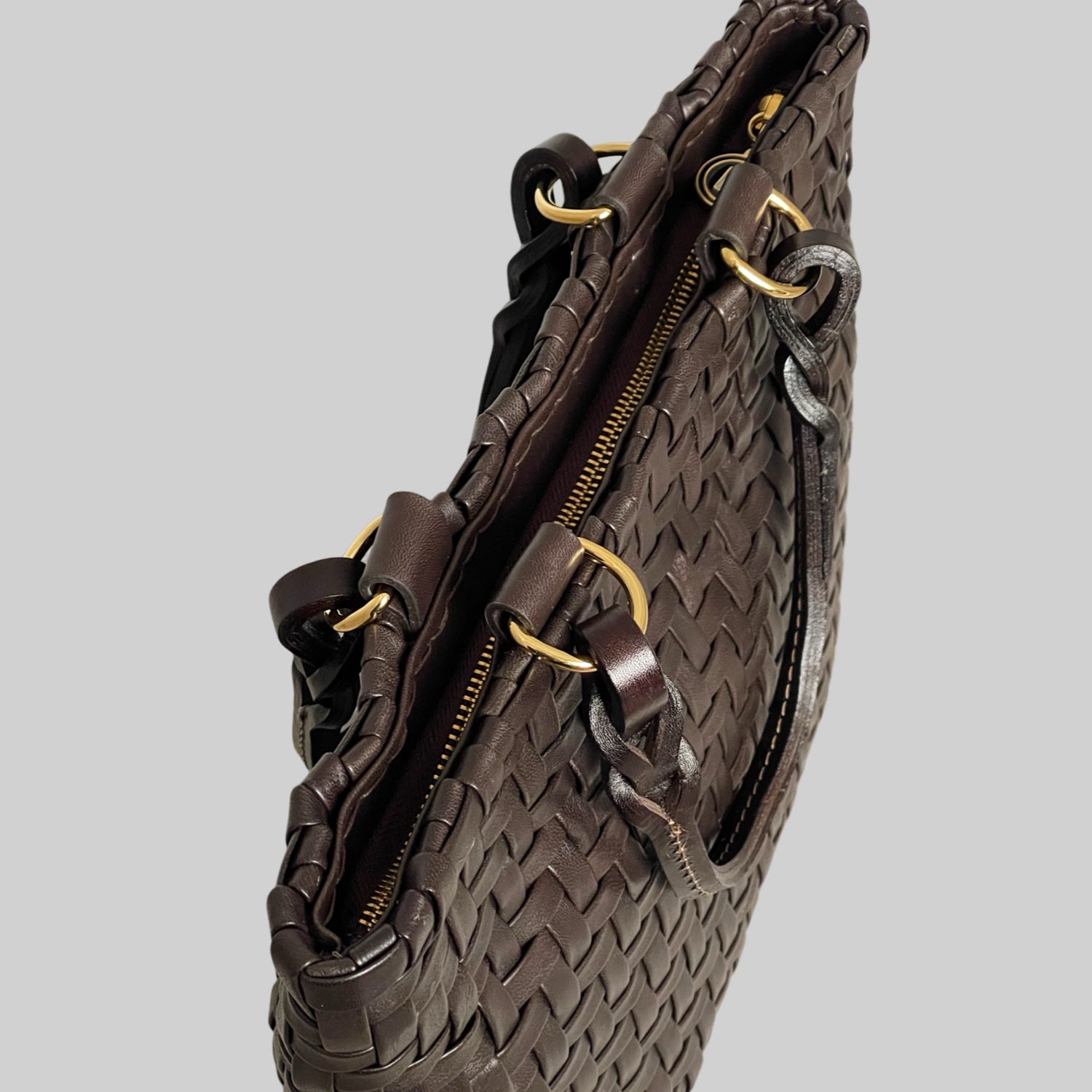 Ribichini Safari Lady-vesken i sjokolade, med flettet lammeskinn og glidelås, kombinerer stil og funksjonalitet på en elegant måte.