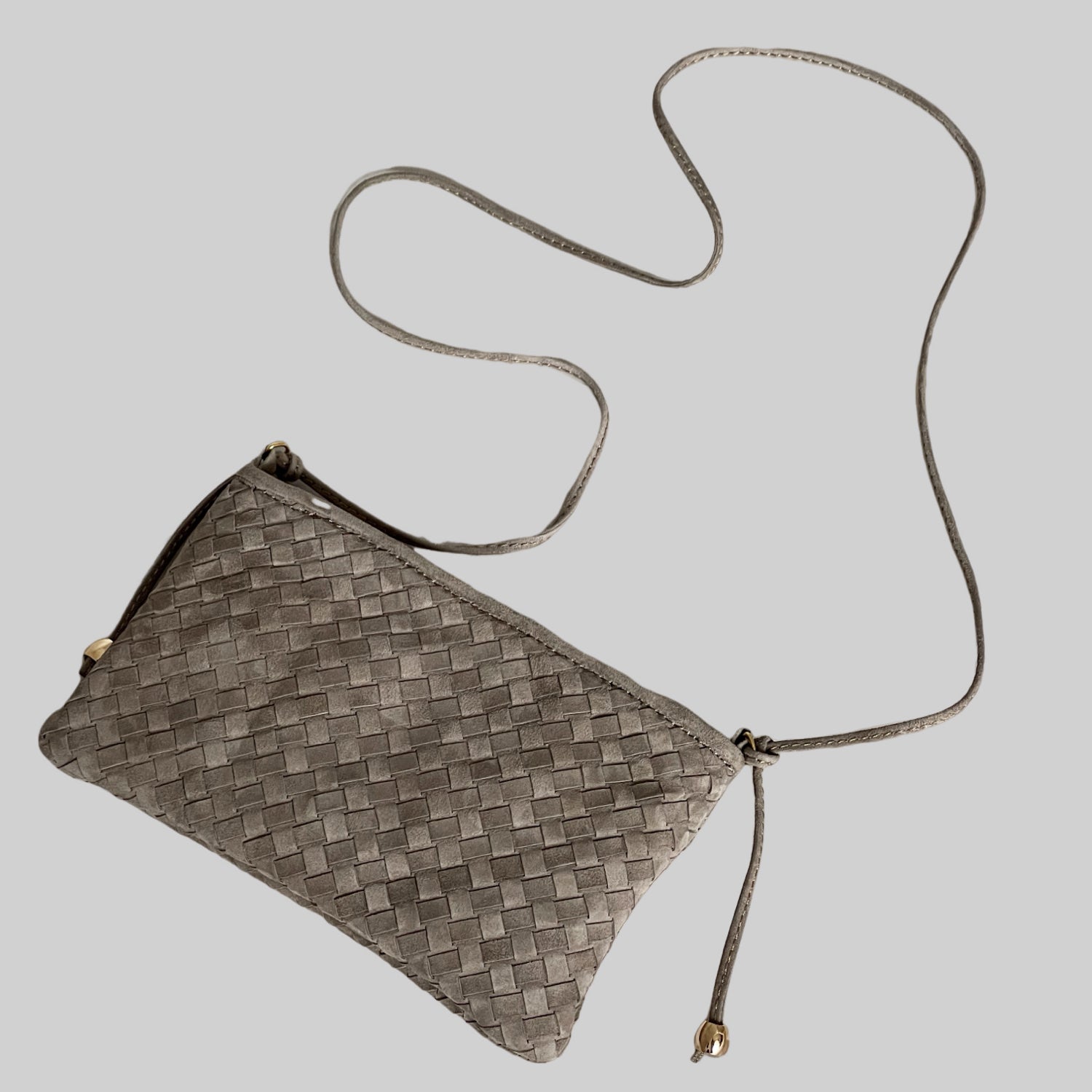 Ribichini Camper clutch i fargen smoke i semsket lammeskinn med flettet design og lang skulderrem, vist ovenfra.