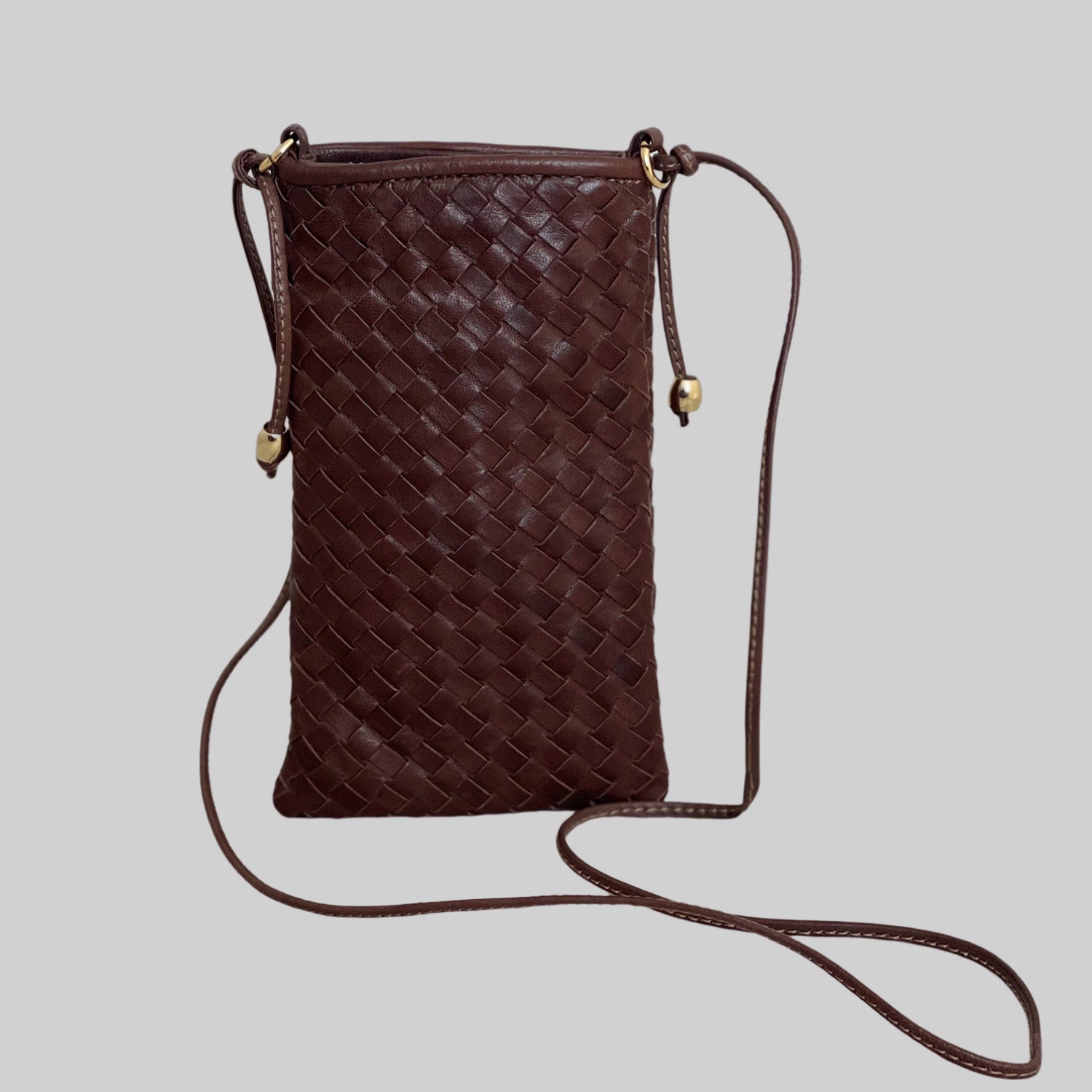 En Ribichini Pocket i brun, en elegant, liten skinnveske ideell for mobil, kredittkort og hemmelige notater.