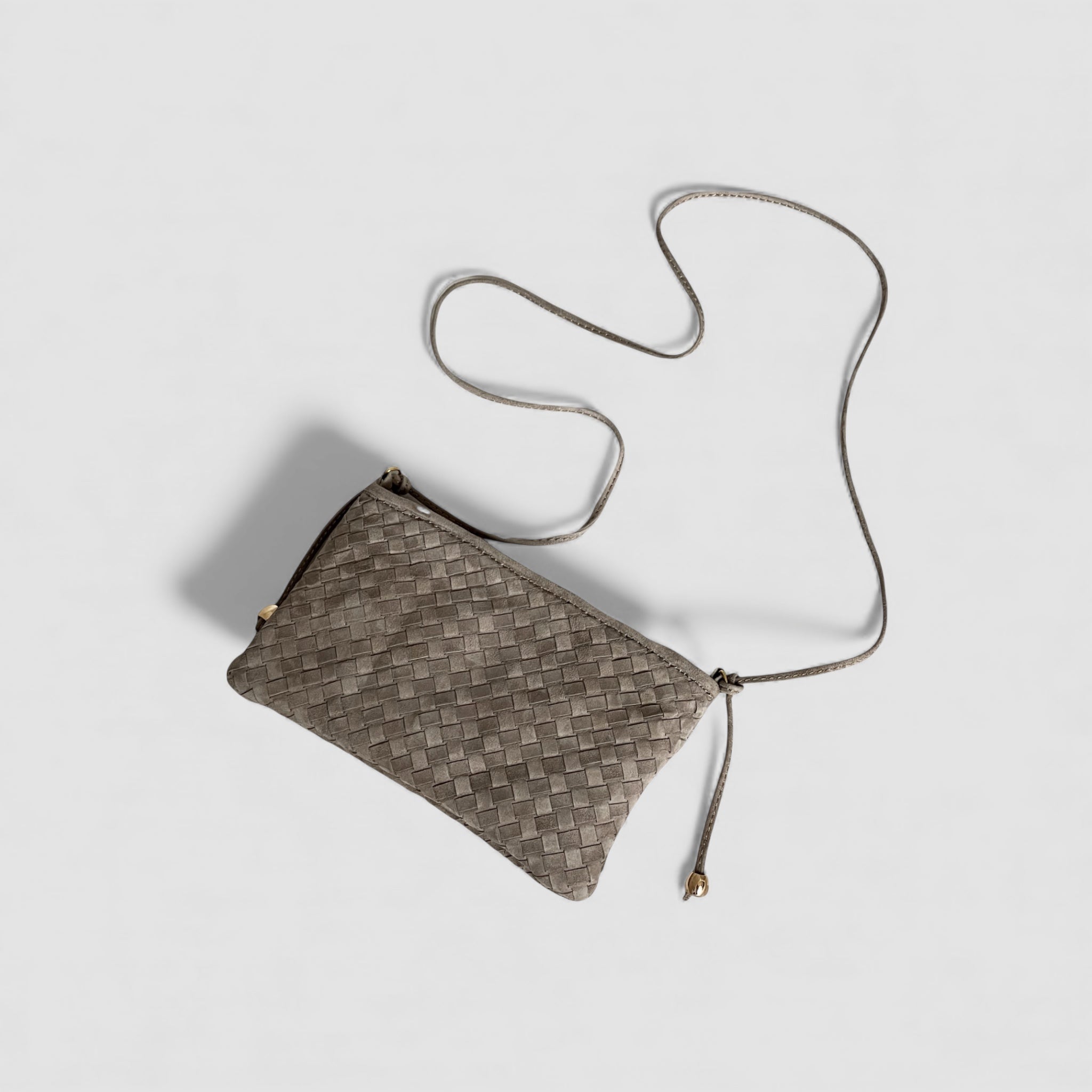 Ribichini Camper clutch i fargen smoke i semsket lammeskinn med flettet design og lang skulderrem, vist ovenfra.