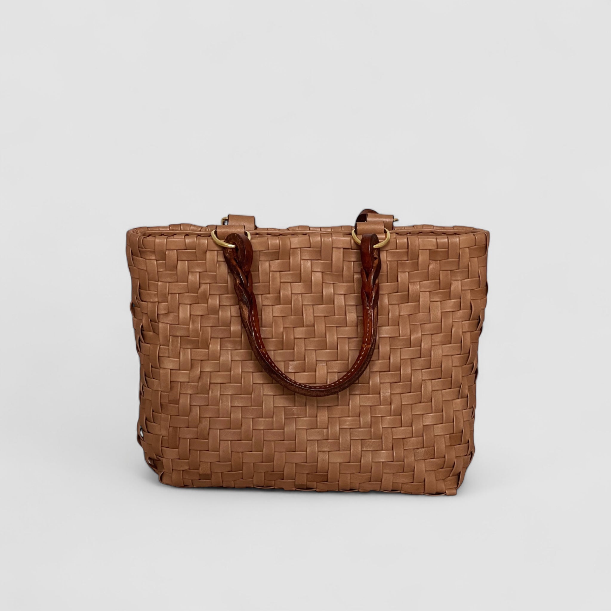 Ribichini Safari Lady skinnvesken i cognac kombinerer stil og funksjonalitet med sitt flettemønster og praktiske størrelse.