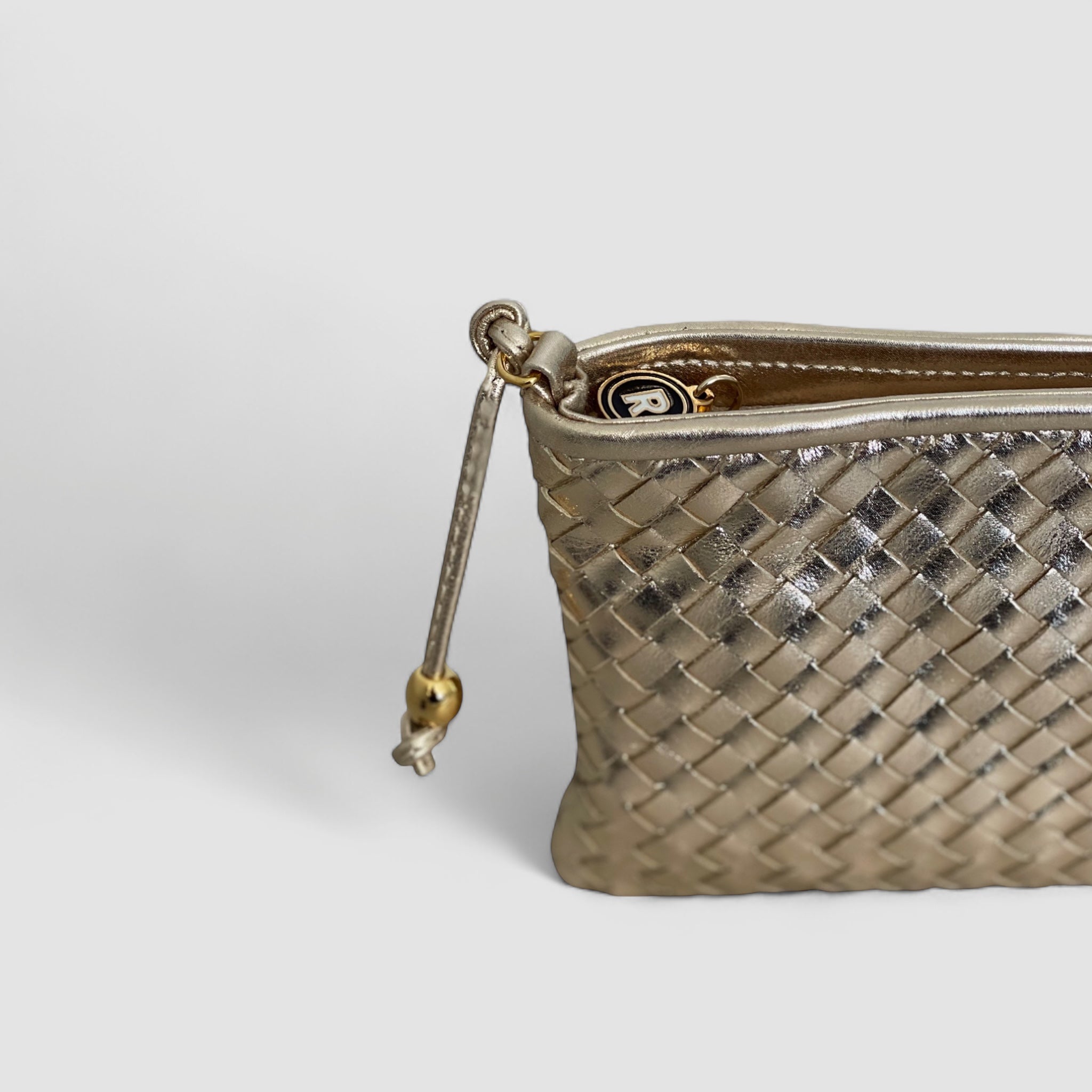 Ribichini Camper Clean Clutch i gull: Unik design med flettet lammeskinn og ikonisk gullglidelås. Eleganse og stil i ett.