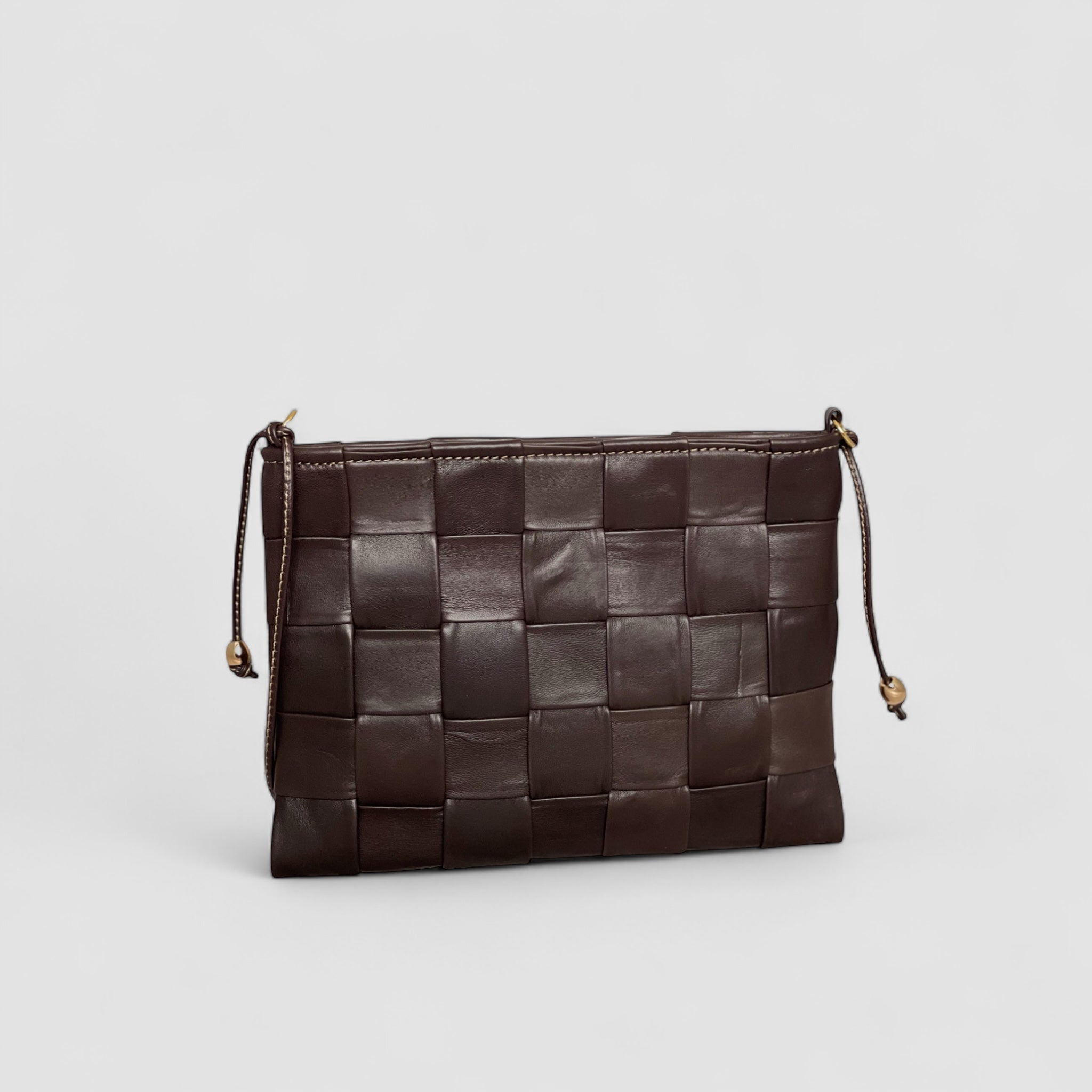 Ribichini Square Clutch i fargen chocolate: Elegant og kompakt veske, perfekt for små nødvendigheter. Unikt flettet design i mykt lammeskinn.