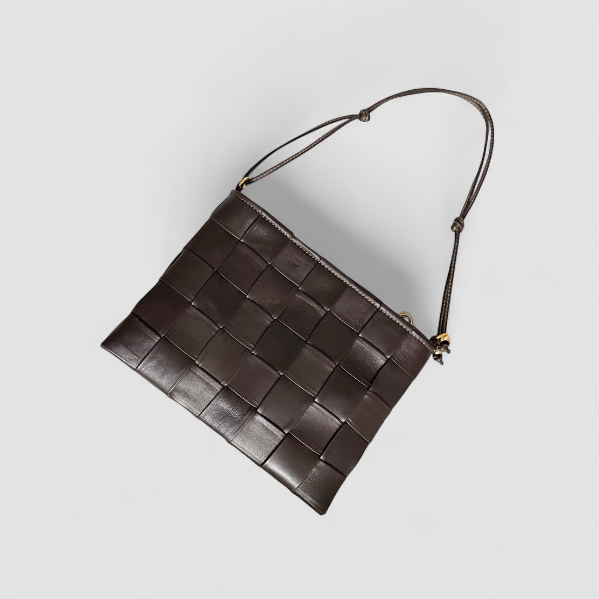 Ribichini Square Clutch i fargen chocolate: Elegant og kompakt design med store, flettete ruter.Tynn skulderstropp for ekstra bærbarhet.
