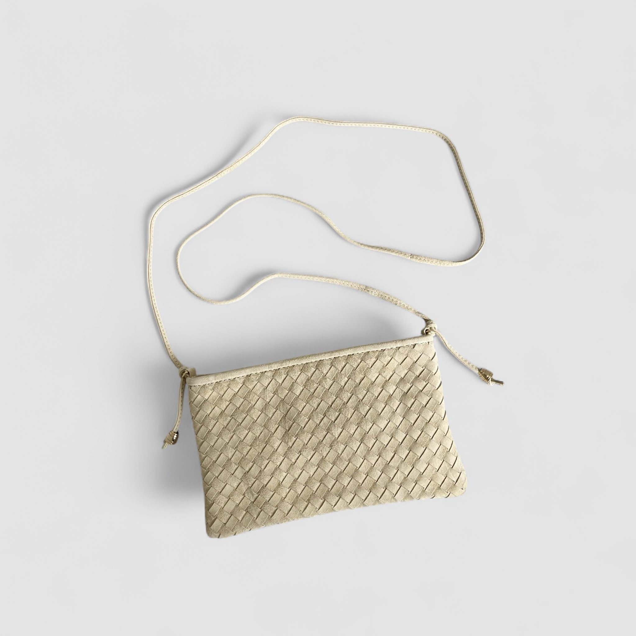 Ribichini Camper clutch i kremfarge. Den er laget av semsket lammeskinn, har et flettet design og gulldetaljer og justerbar skulderstropp.