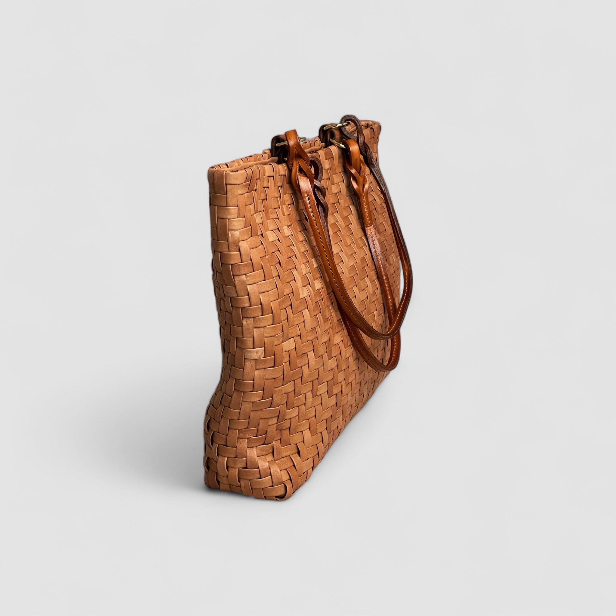 Sidevisning av Ribichini Safari-vesken i cognacfarget lammeskinn har et unikt fiskebensmønster.