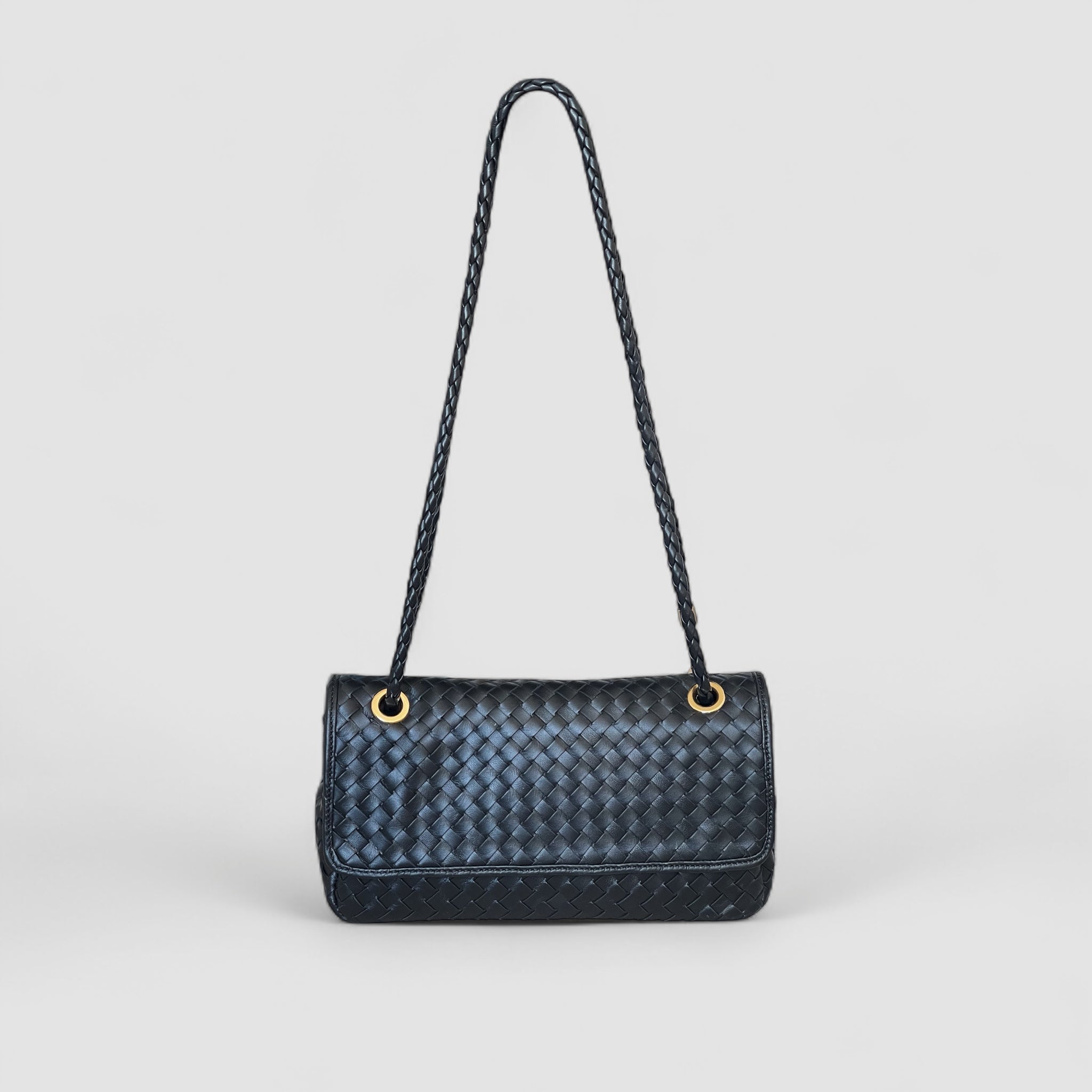 Ribichini Envelope-clutchen forfra, flettet i sort mykt lammeskinn med gull-detaljer.