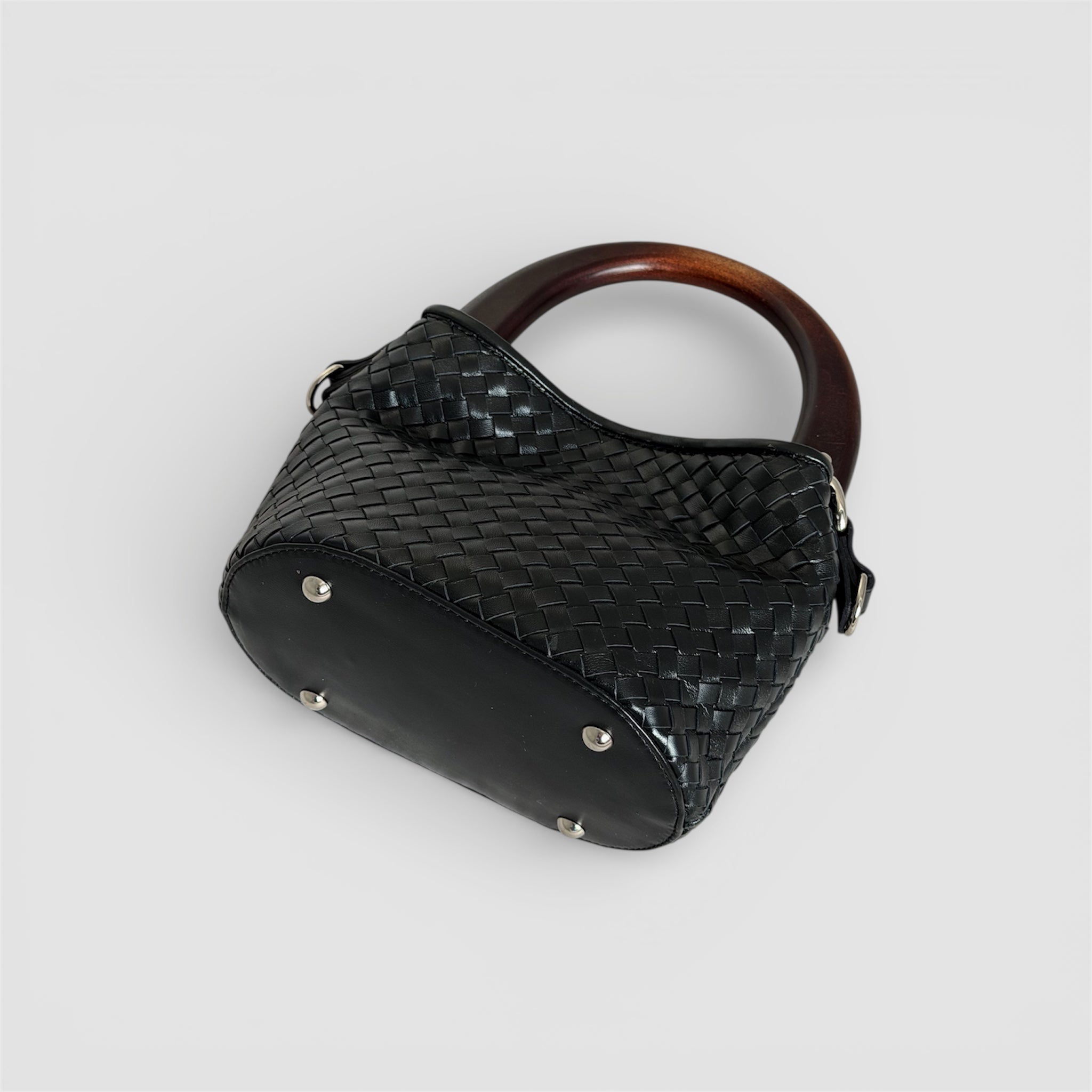 Bunn av Ribichini Albero veske i håndflettet sort skinn med beskyttende metallføtter og trehåndtak.