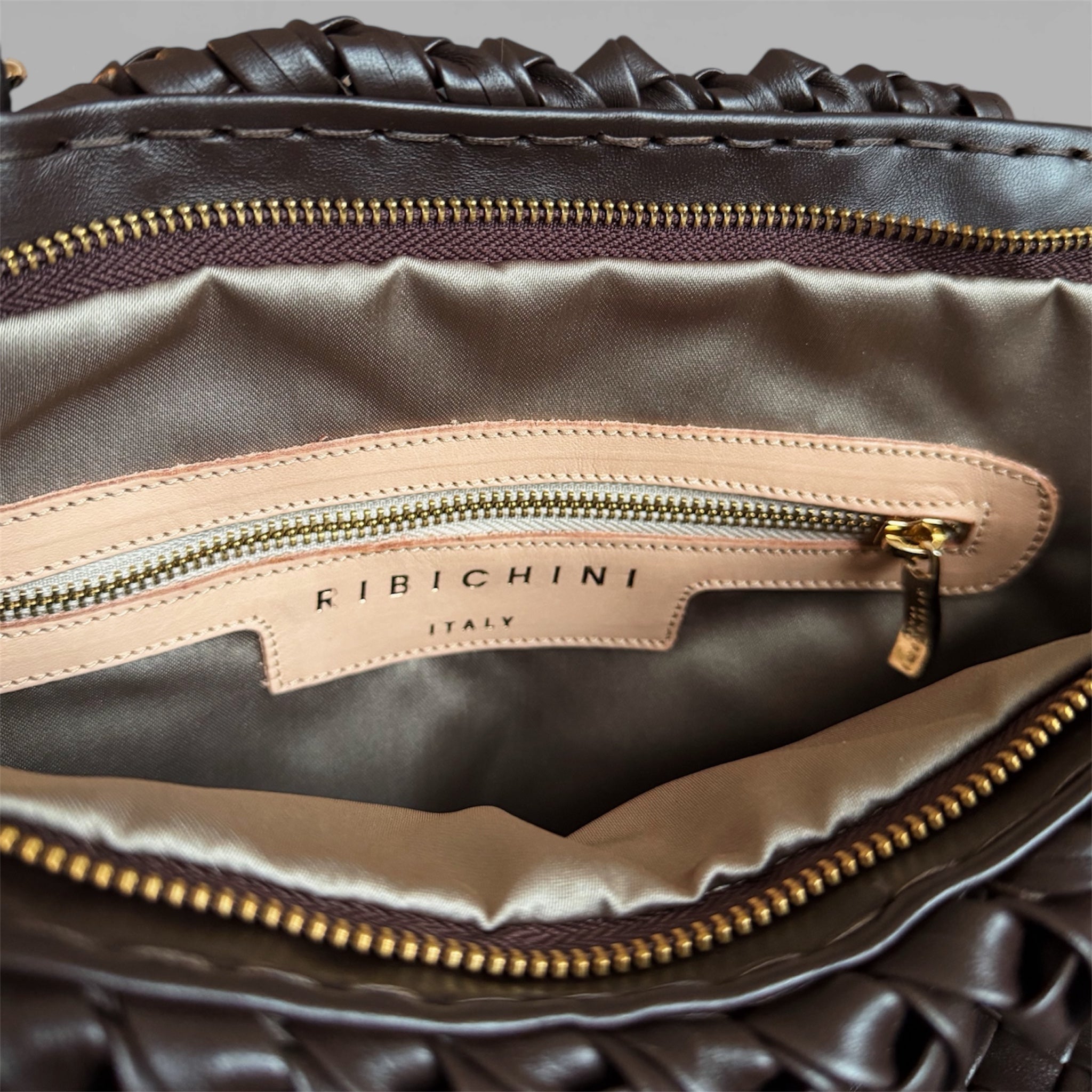 Innsiden av Ribichini Woodstock Classic skinnveske i chocolate viser en gullfarget glidelåslomme og den ikoniske R-logoen.