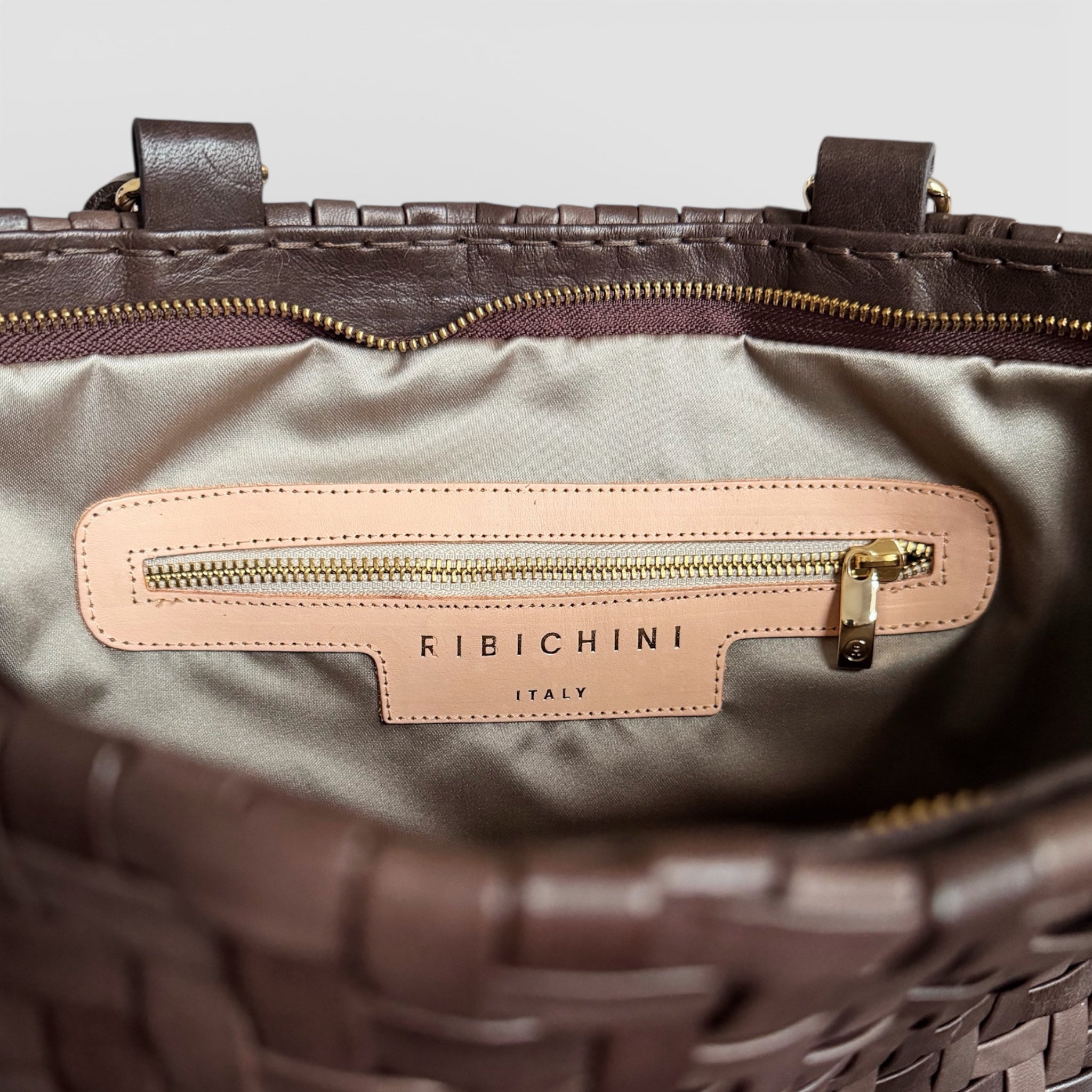 Innvendig detalj av Ribichini Safari i brunt med glidelåslomme, fôret interiør og preget Ribichini Italy-logo i skinn.