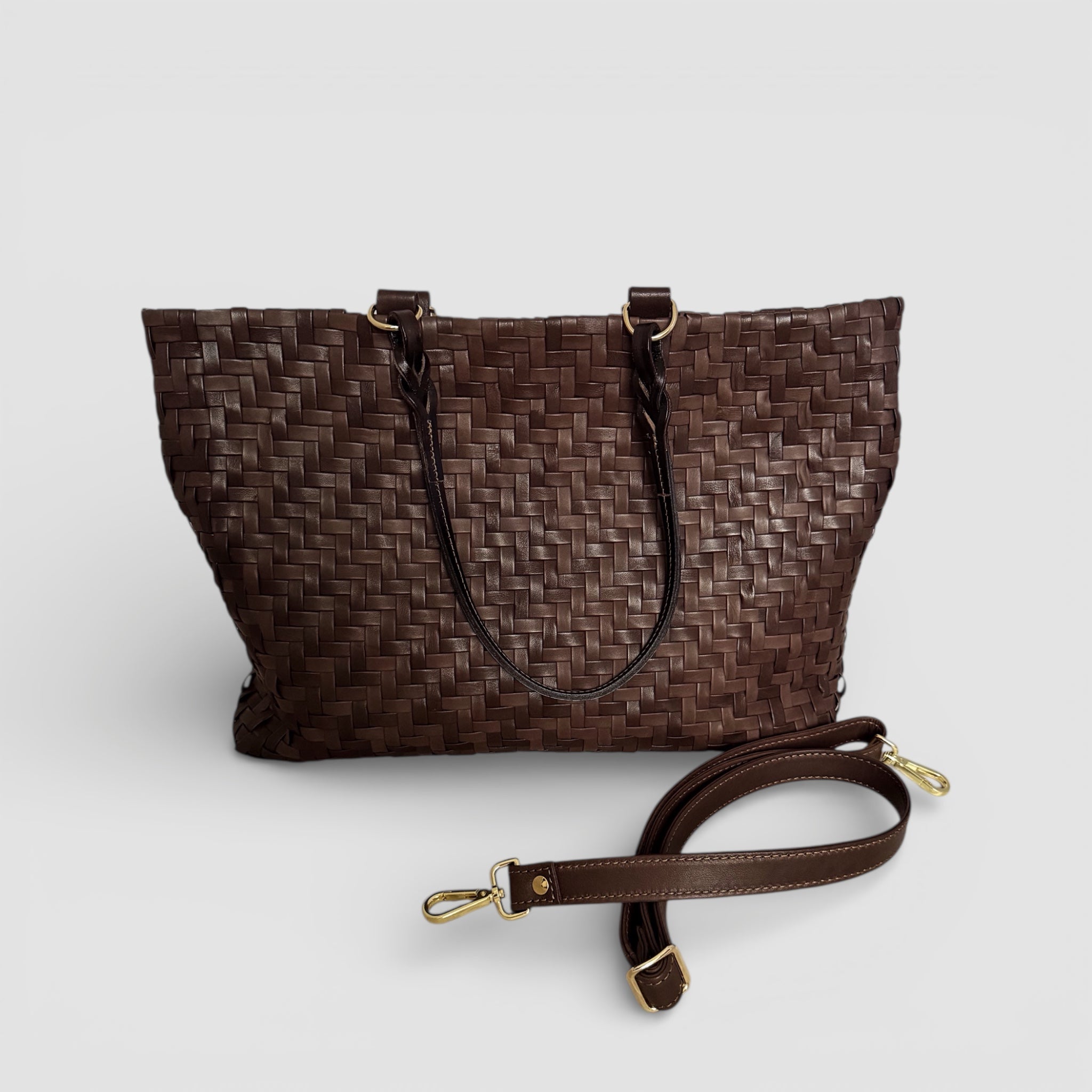 Safari i brunt – håndflettet skinnveske med doble håndtak, avtagbar skulderstropp og elegante gulldetaljer.