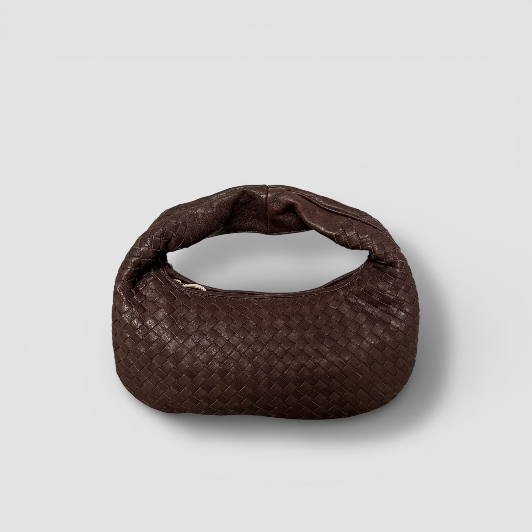 Ribichini Isola Bella i brun farge, flettet skinn, elegant avrundet design, håndlaget i Italia med glidelås i gull.