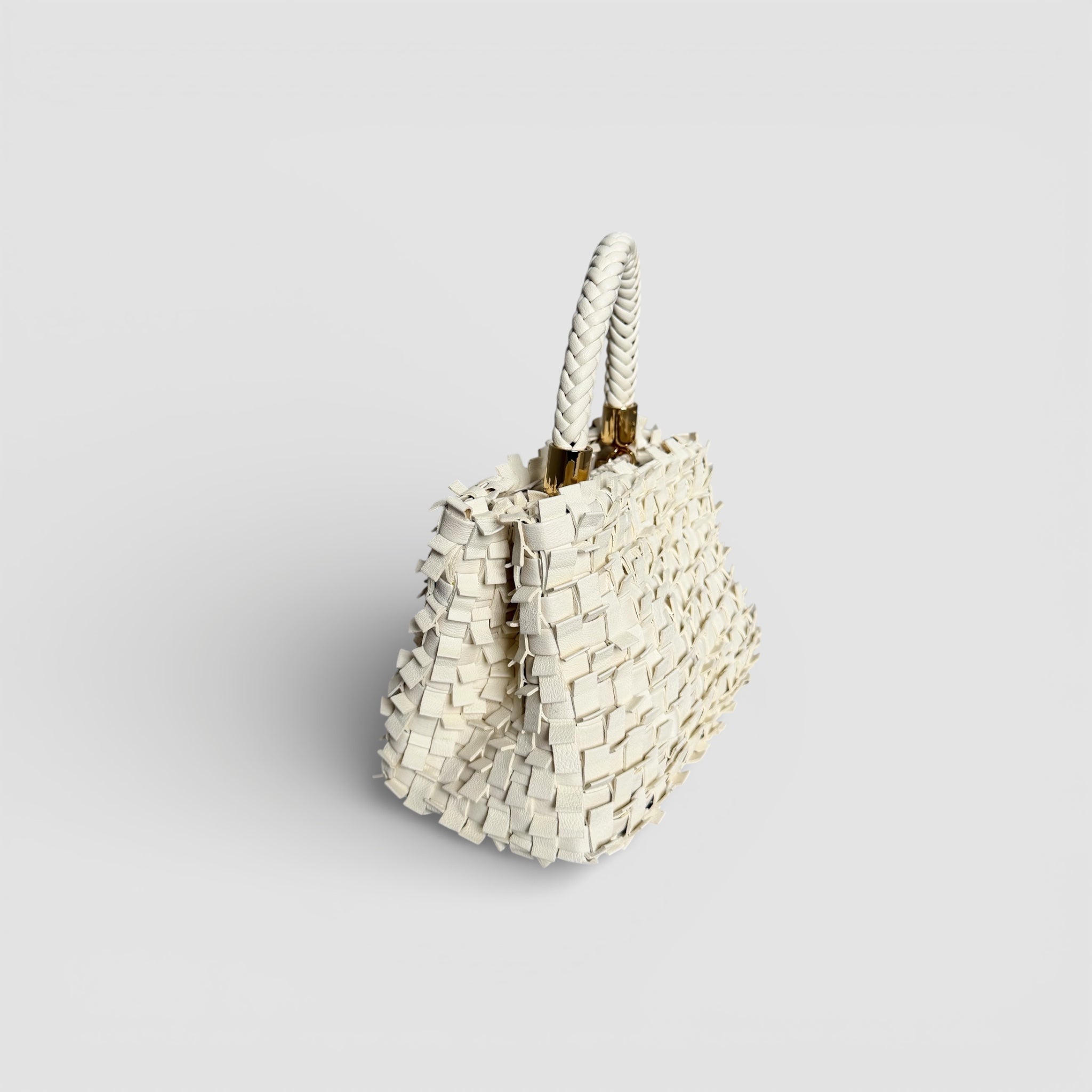 Ribimini Cream fra Ribichini sett fra siden, håndflettet i plissé med flettet hank og gullfargede detaljer.