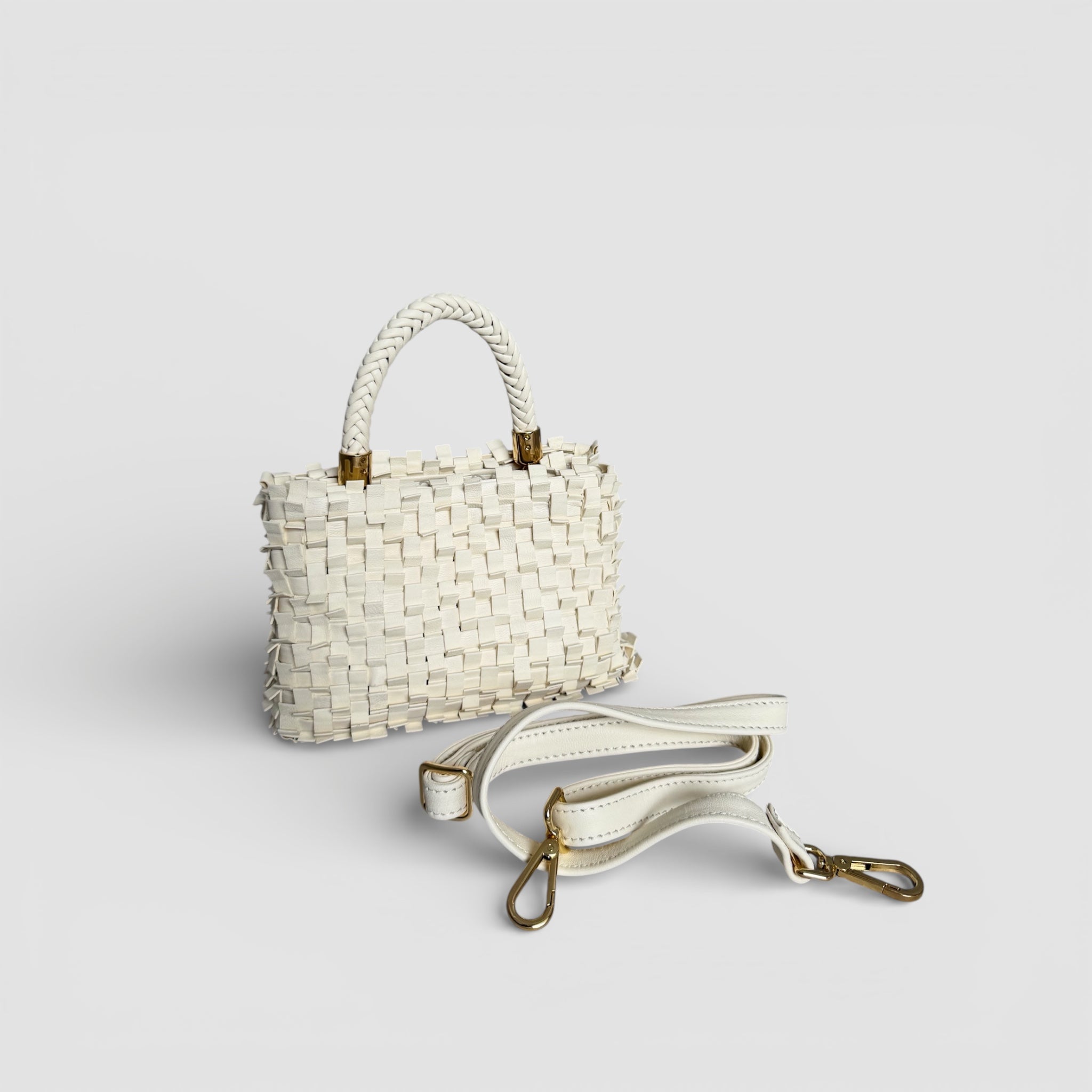 Ribimini Cream fra Ribichini med flettet håndtak og avtagbar skulderrem i skinn med gullfargede detaljer.