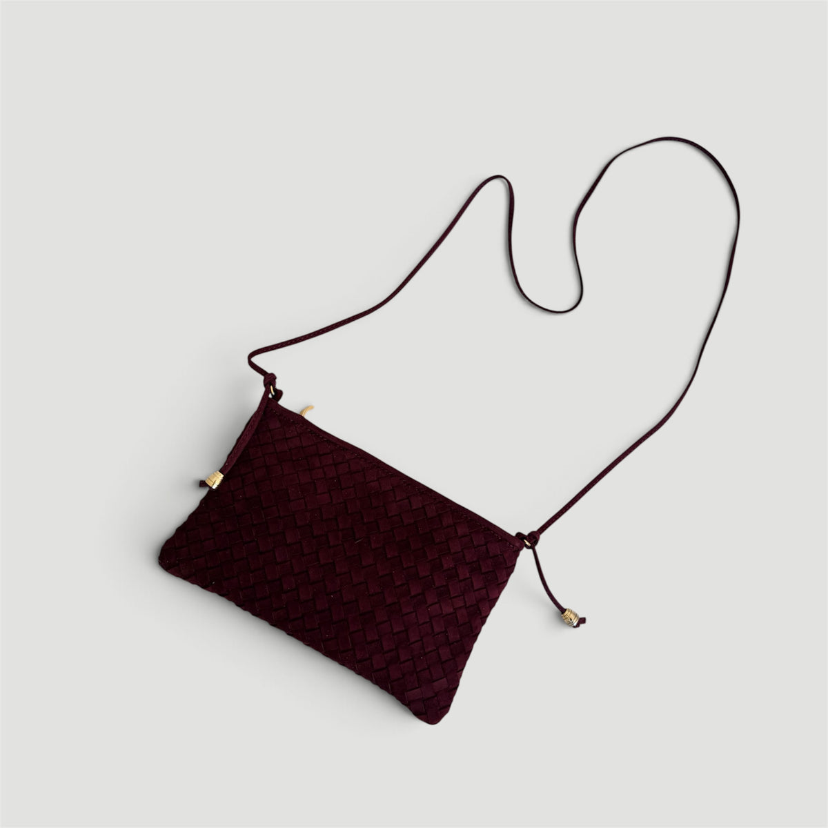 Ribichini Camper Clutch Suede Bordeaux – håndflettet clutch i burgunderrødt semsket lammeskinn med lang skulderrem.