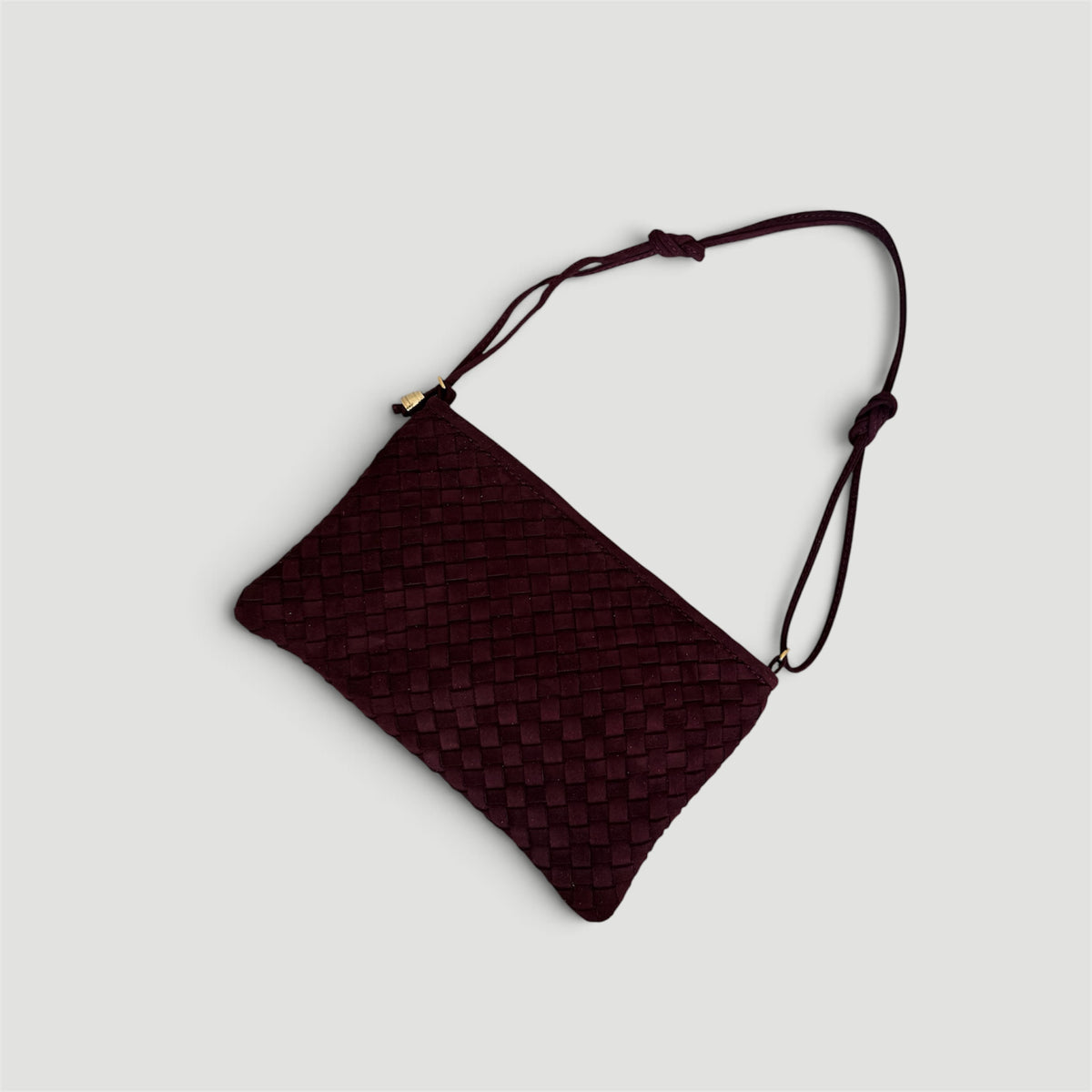 Ribichini Camper Clutch Suede Bordeaux – håndflettet clutch i burgunderrødt semsket lammeskinn med kort, justerbar skulderrem.