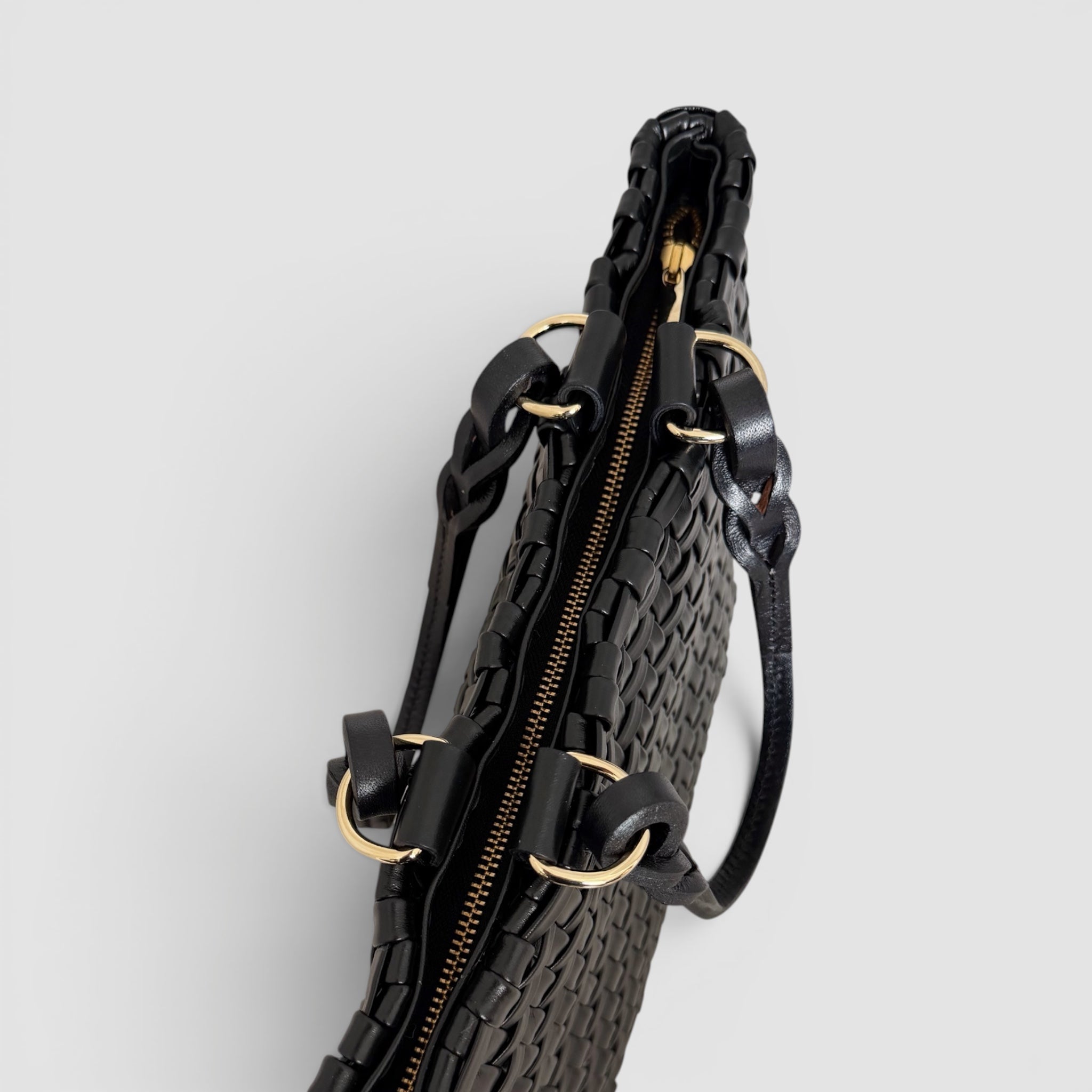  Ribichini Safari Lady-vesken i sort, med flettet lammeskinn og glidelås, kombinerer stil og funksjonalitet på en elegant måte.