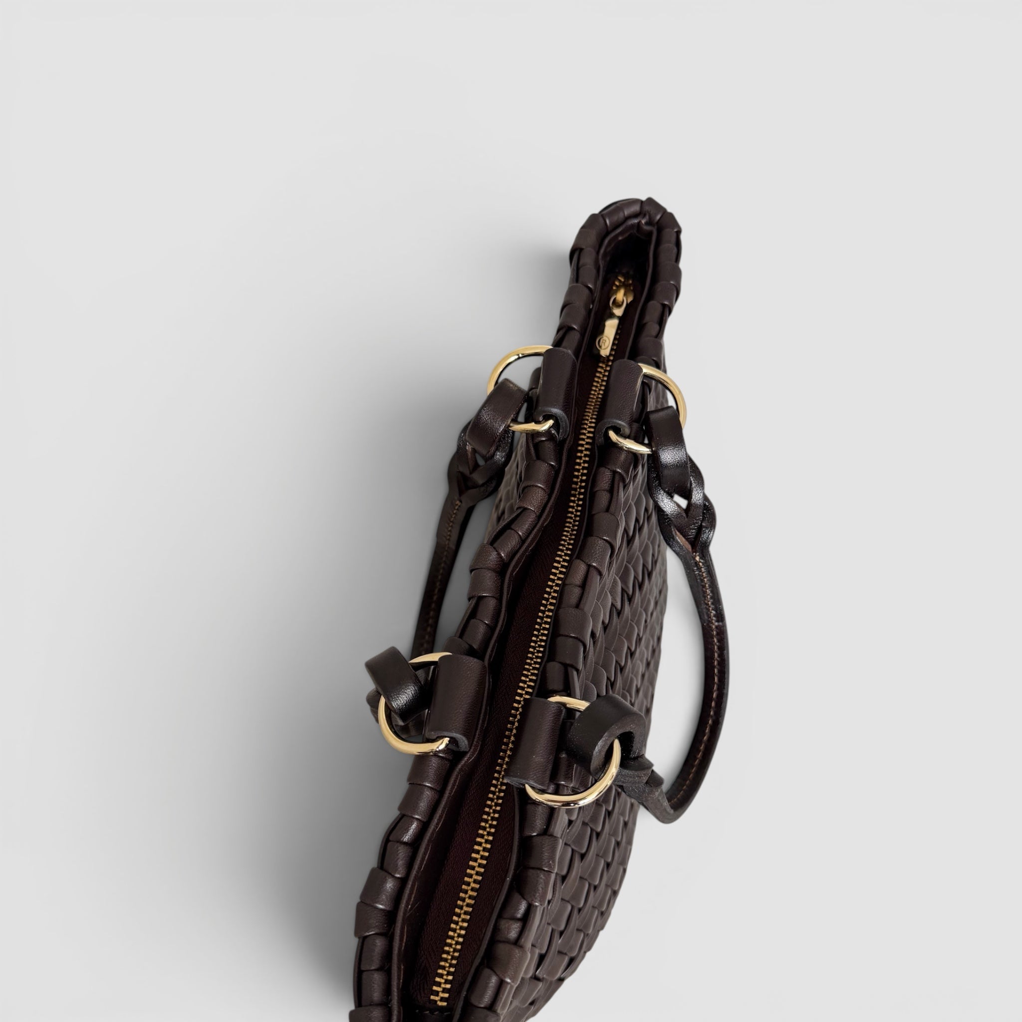 Ribichini Safari Lady-vesken i sjokolade, med flettet lammeskinn og glidelås, kombinerer stil og funksjonalitet på en elegant måte.