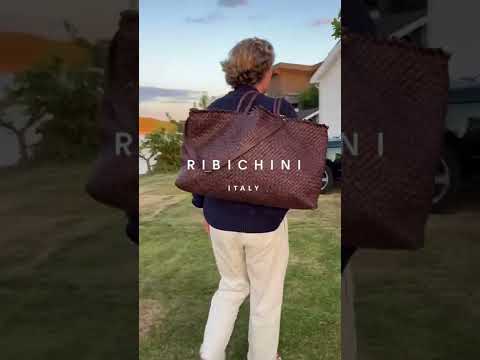 En ung mann bærer Ribichini Woodstock Weekend og Crossover veske i brunt skinn, går fra bryggen til en Range Rover.