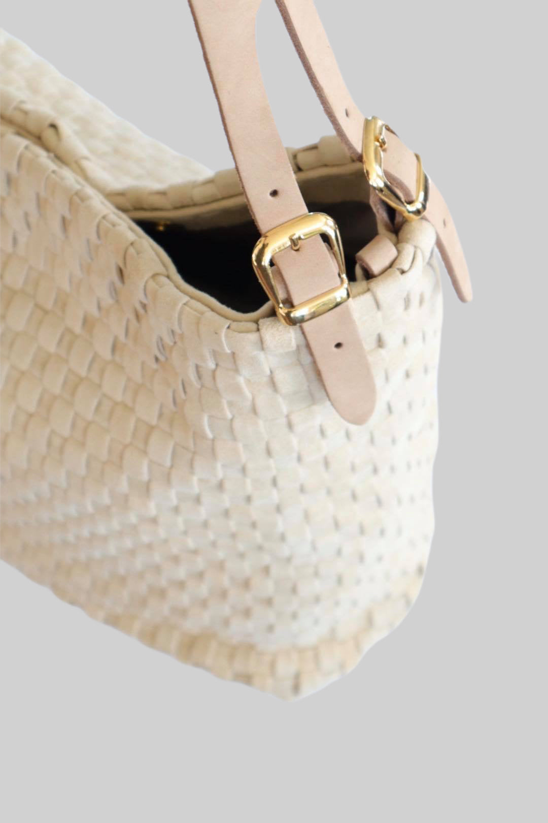 Bildet gir et nærbilde av sidene på Ribichini Camper-skinnvesken, med detaljert flettet skinn og elegante gulldetaljer, som viser veskens sofistikerte utførelse og materialkvalitet.
