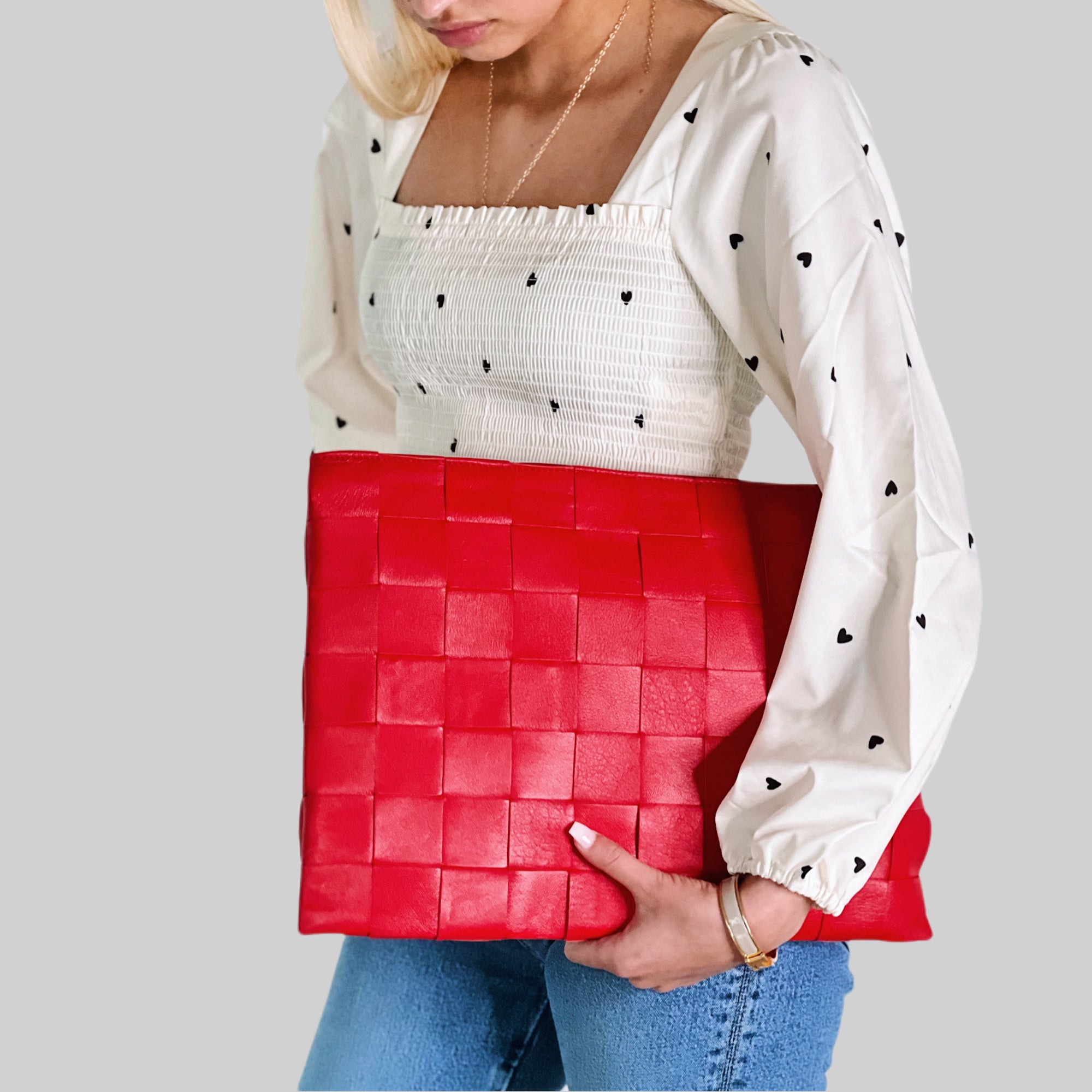 Stilig og profesjonell, kvinnen bærer stolt en Ribichini Square Laptop-veske i rødt, som tilfører elegant og sofistikert preg til antrekket.
