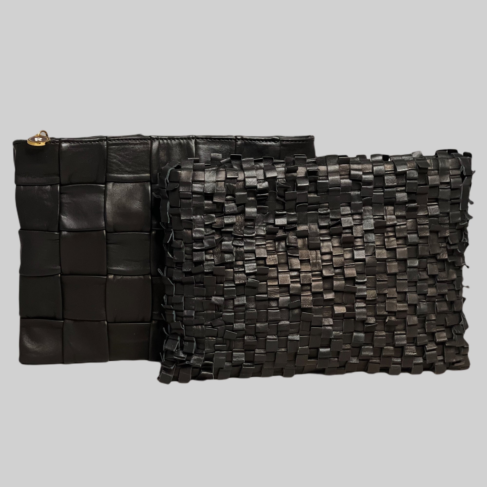 På bildet vises to Ribichini clutcher: Square Clutch i sort med store ruter og Loren Clutch i sort med plisse-fletting. Begge clutcher har unikt og moderne design.