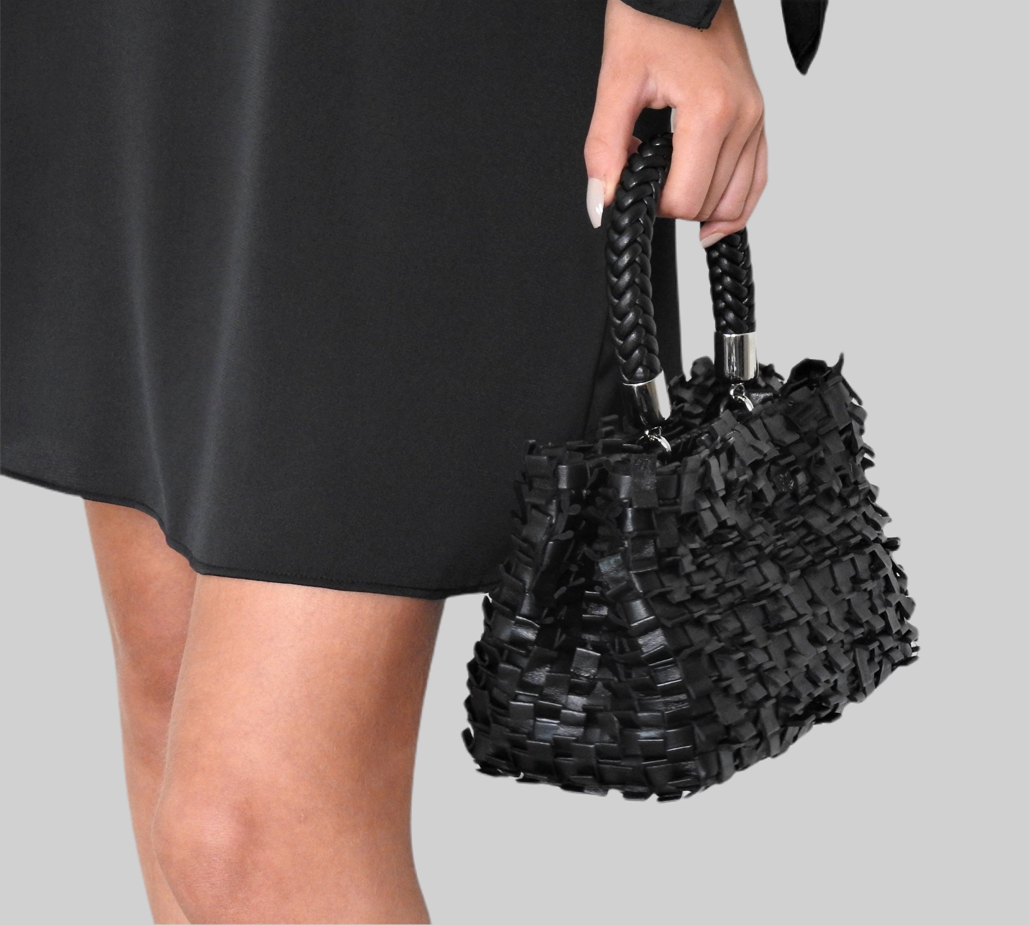 Kvinne i sort kjole og Ribimini-veske med sølv. Moderne eleganse møter klassisk stil.