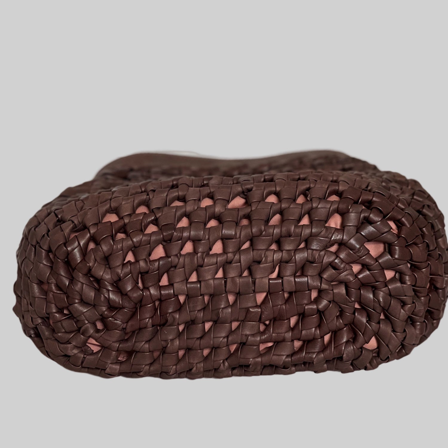 Ribichini Donna-veskens underside viser et intrikat håndflettet mønster i brunt skinn, som gir en tekstur av jevne løkker og knuter. Solid og godt håndverk.