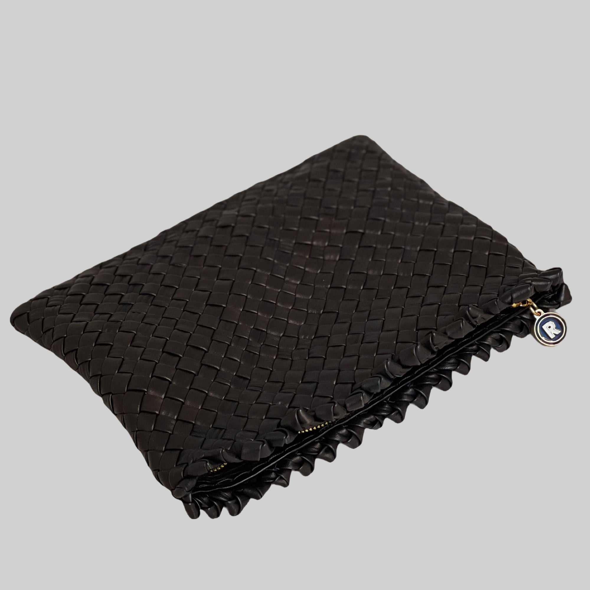 Ribichini Woodstock clutch i sort. Denne modellen, vist uten skulderrem, fremhever håndverket i flettingen som gir en luksuriøs følelse ved berøring. 